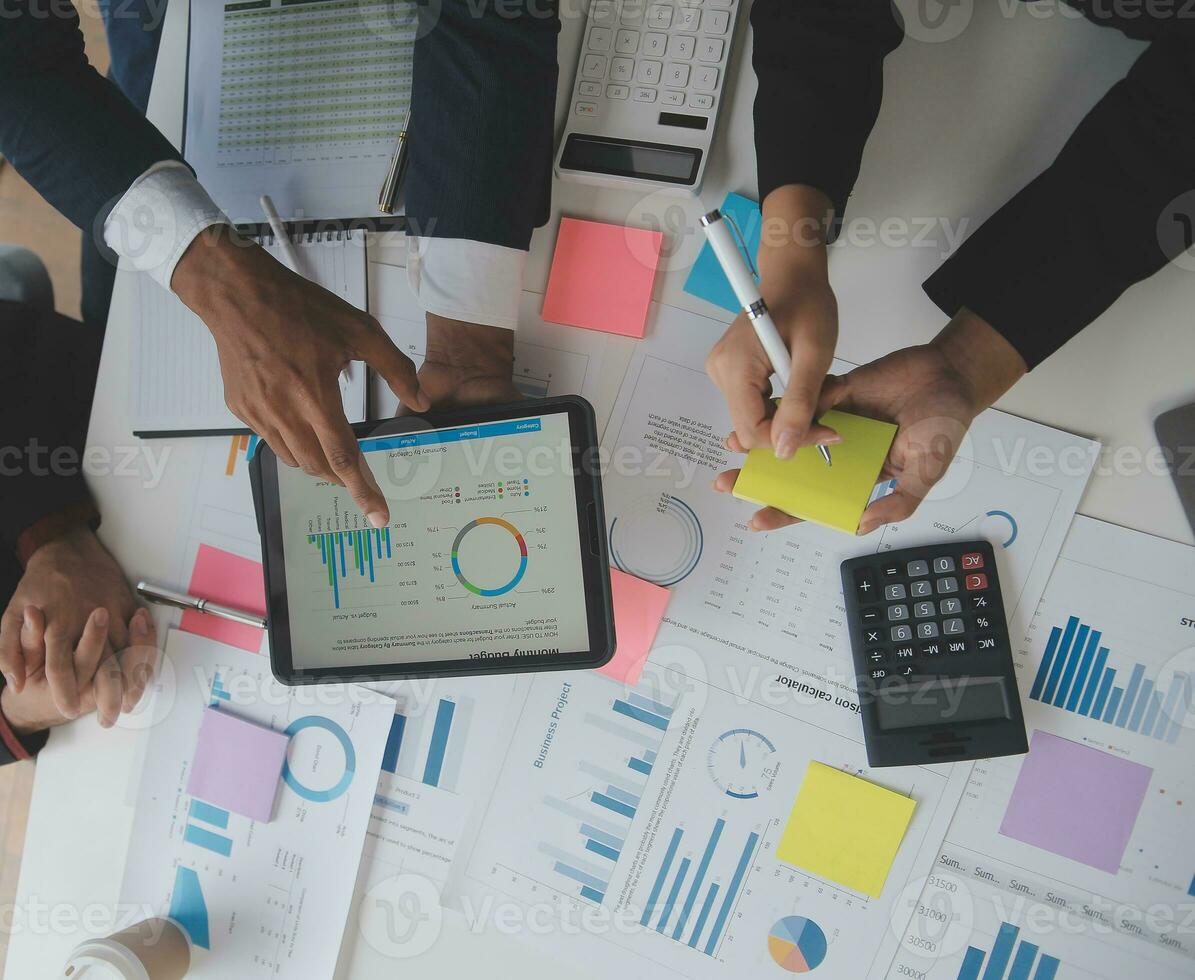 Financial analysts analyze business financial reports on a digital tablet planning investment project during a discussion at a meeting of corporate showing the results of their successful teamwork. photo