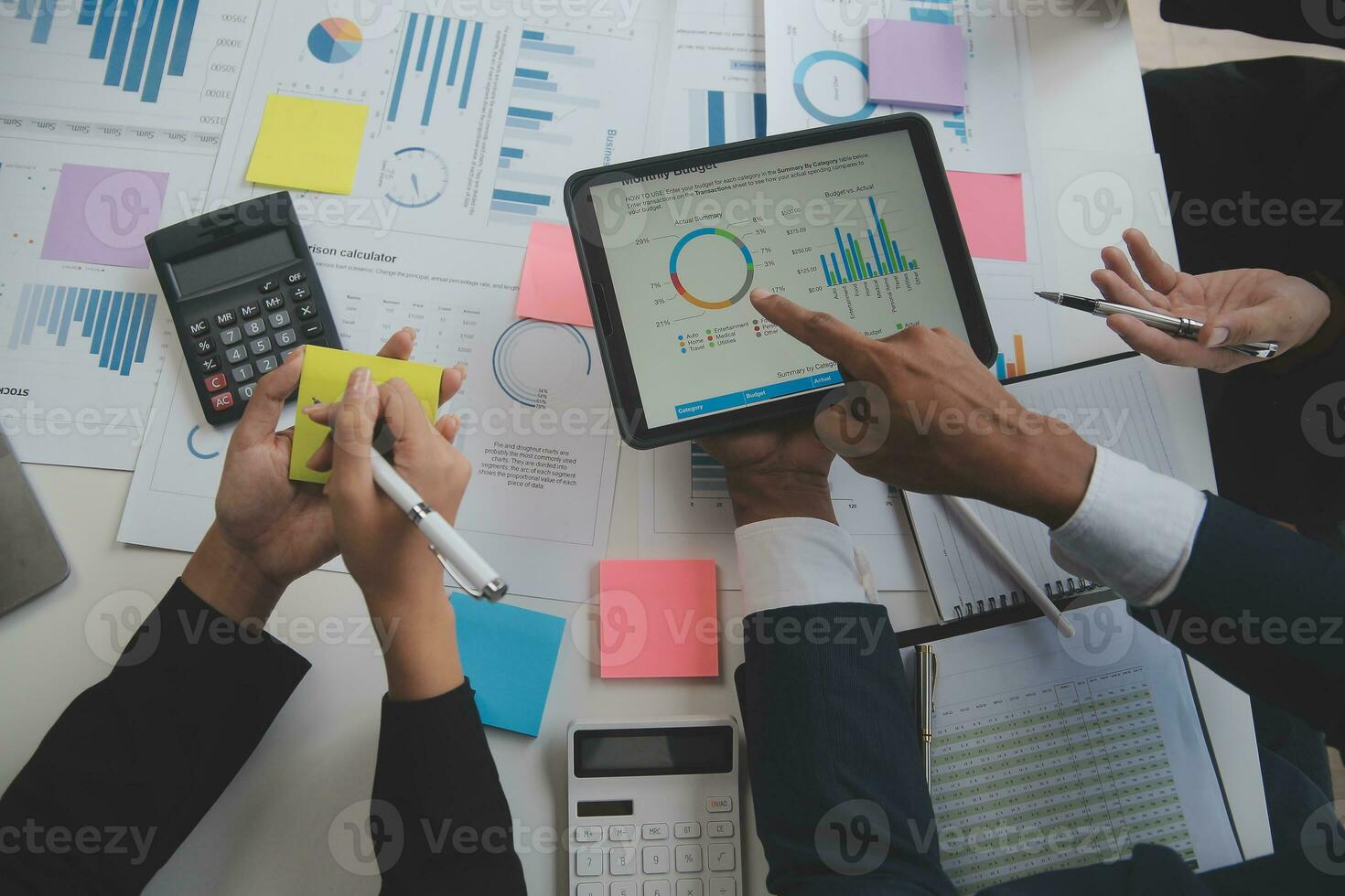 Financial analysts analyze business financial reports on a digital tablet planning investment project during a discussion at a meeting of corporate showing the results of their successful teamwork. photo