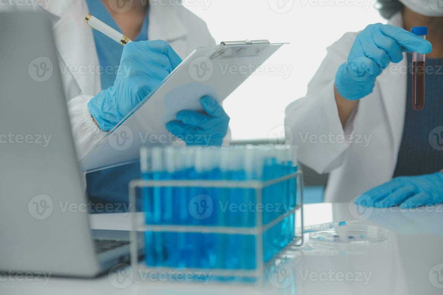 Health care researchers working in life science laboratory. Young female research scientist and senior male supervisor preparing and analyzing microscope slides in research lab. photo