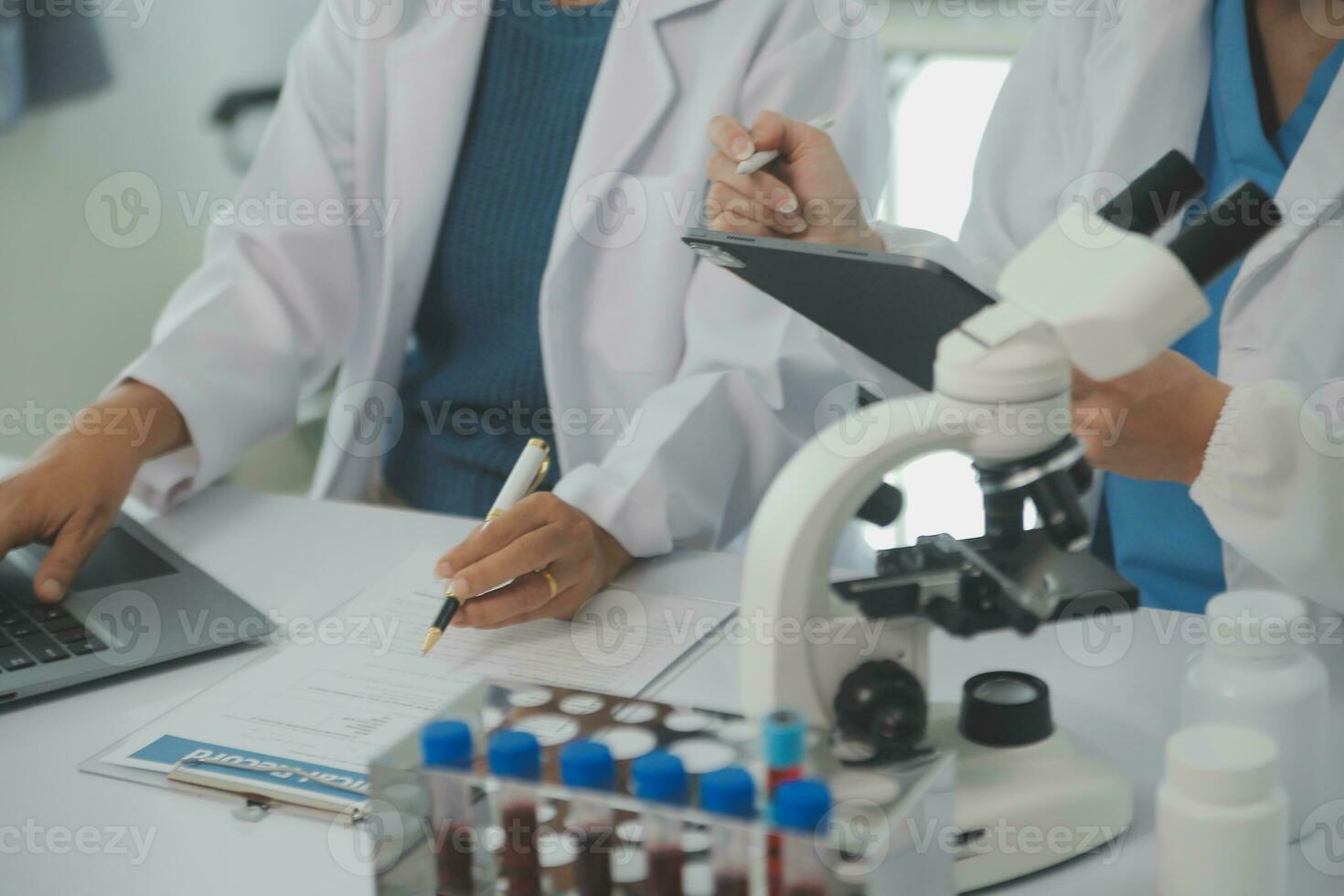 Health care researchers working in life science laboratory. Young female research scientist and senior male supervisor preparing and analyzing microscope slides in research lab. photo
