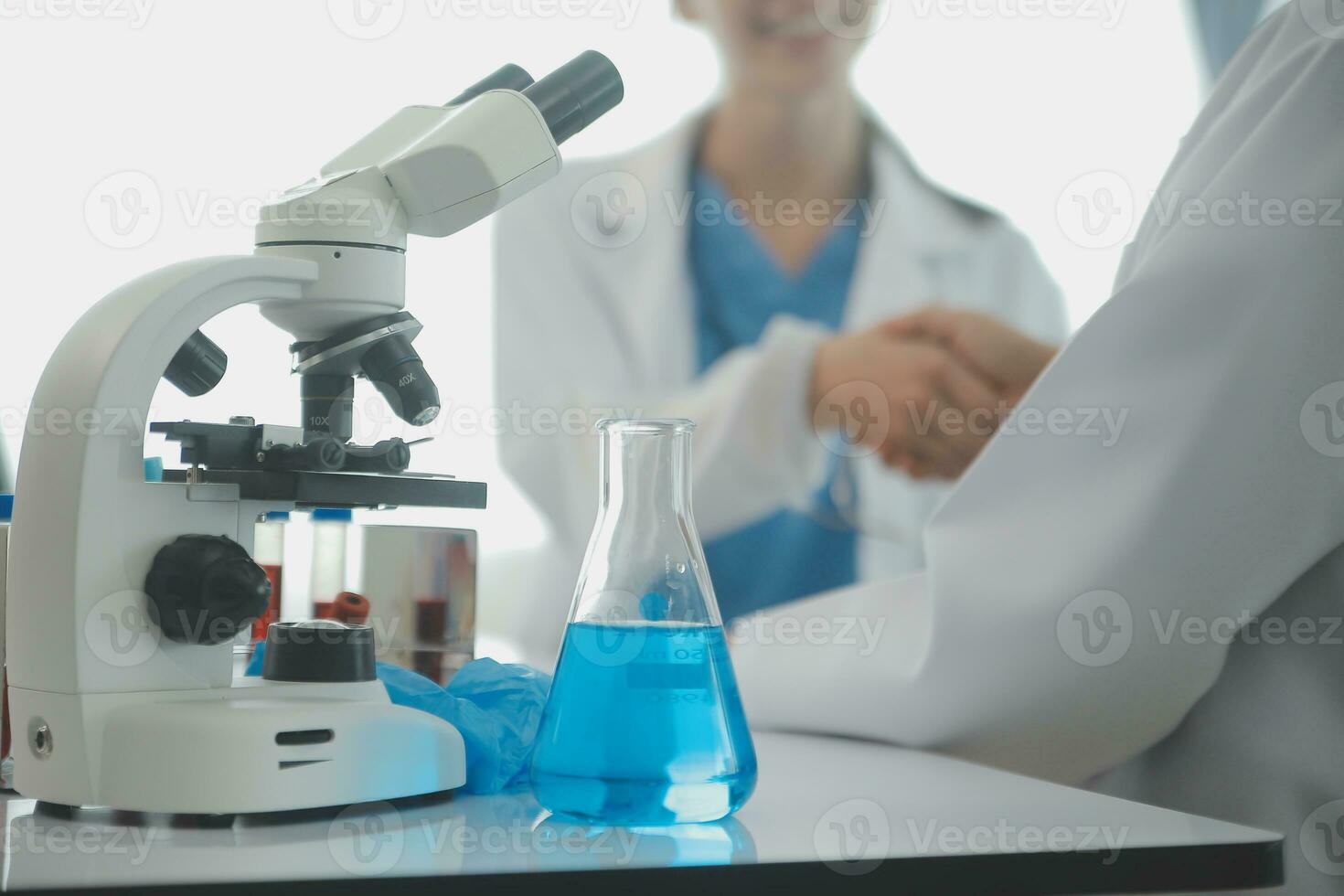 Health care researchers working in life science laboratory. Young female research scientist and senior male supervisor preparing and analyzing microscope slides in research lab. photo