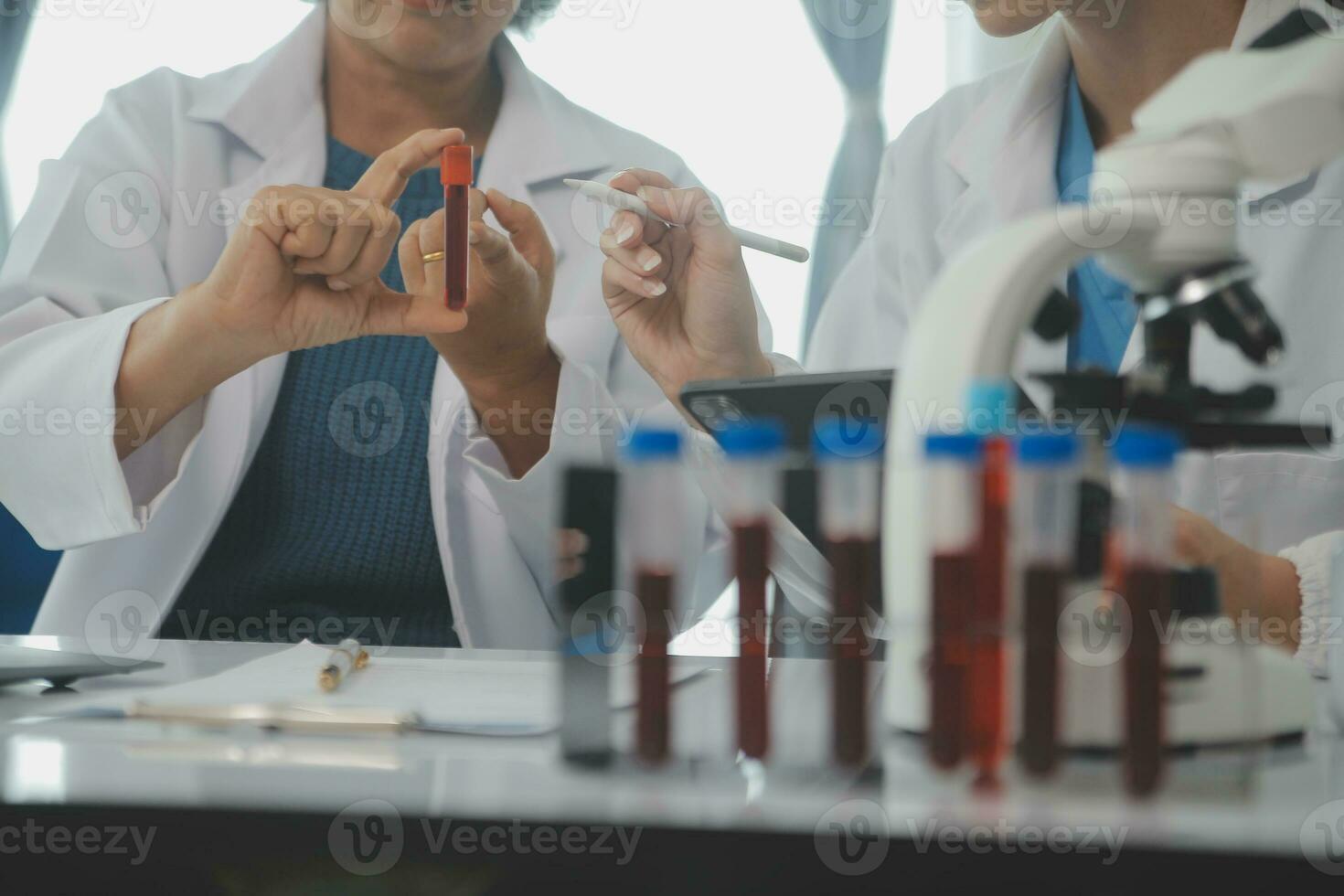 Health care researchers working in life science laboratory. Young female research scientist and senior male supervisor preparing and analyzing microscope slides in research lab. photo