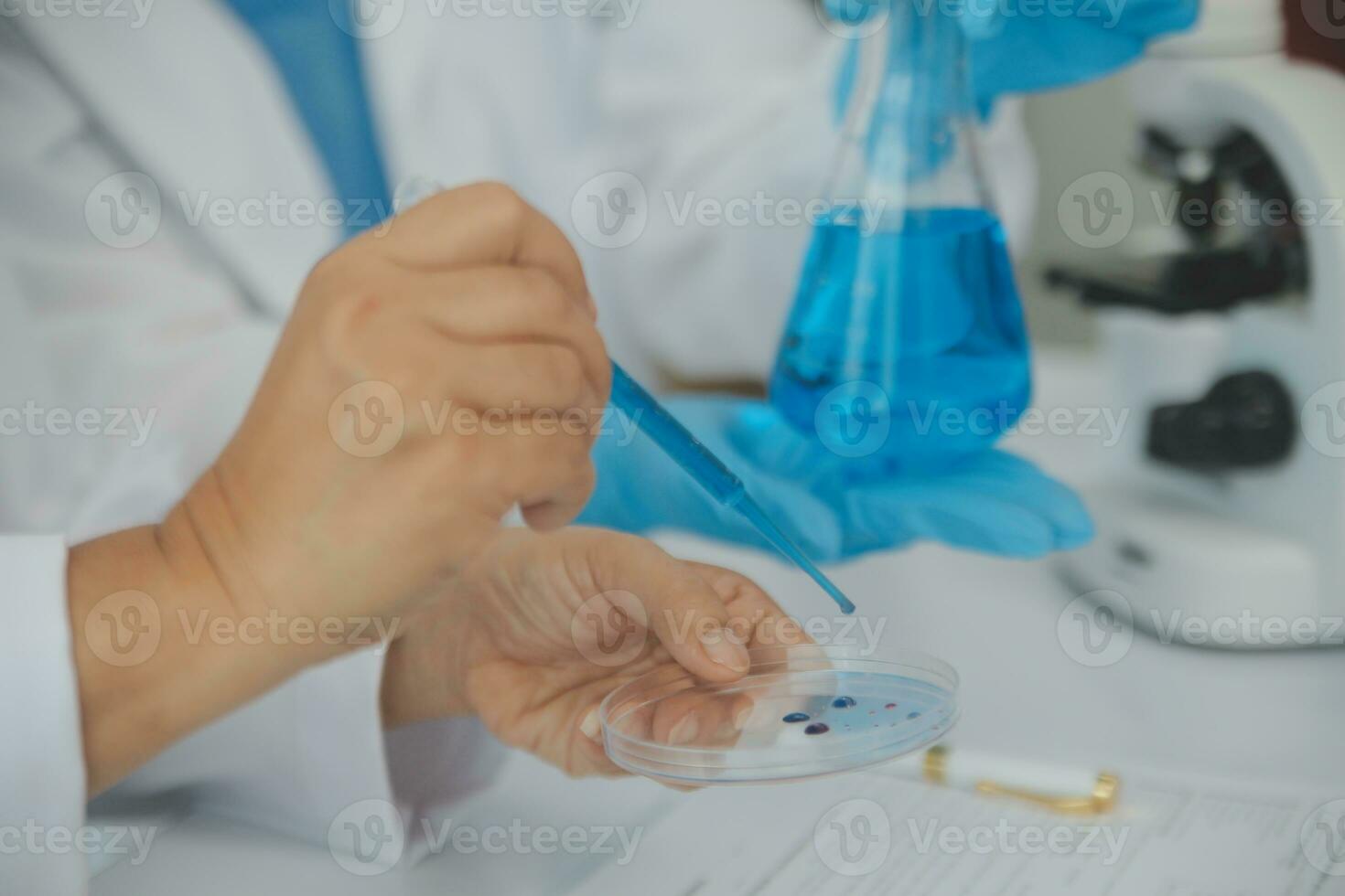 Health care researchers working in life science laboratory. Young female research scientist and senior male supervisor preparing and analyzing microscope slides in research lab. photo