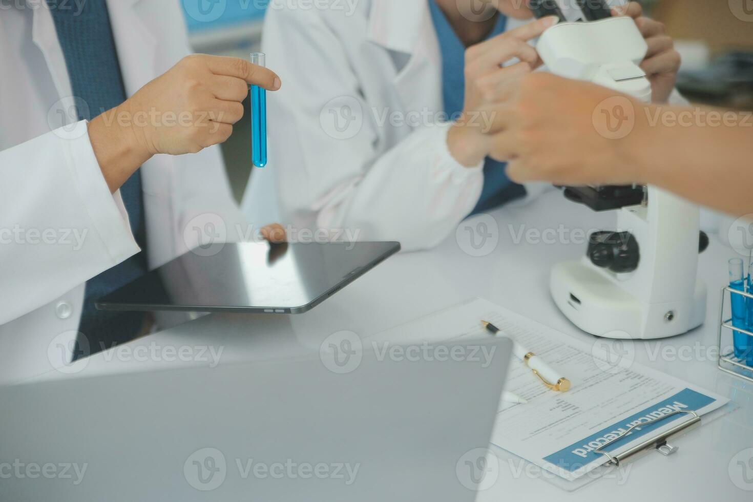 Health care researchers working in life science laboratory. Young female research scientist and senior male supervisor preparing and analyzing microscope slides in research lab. photo