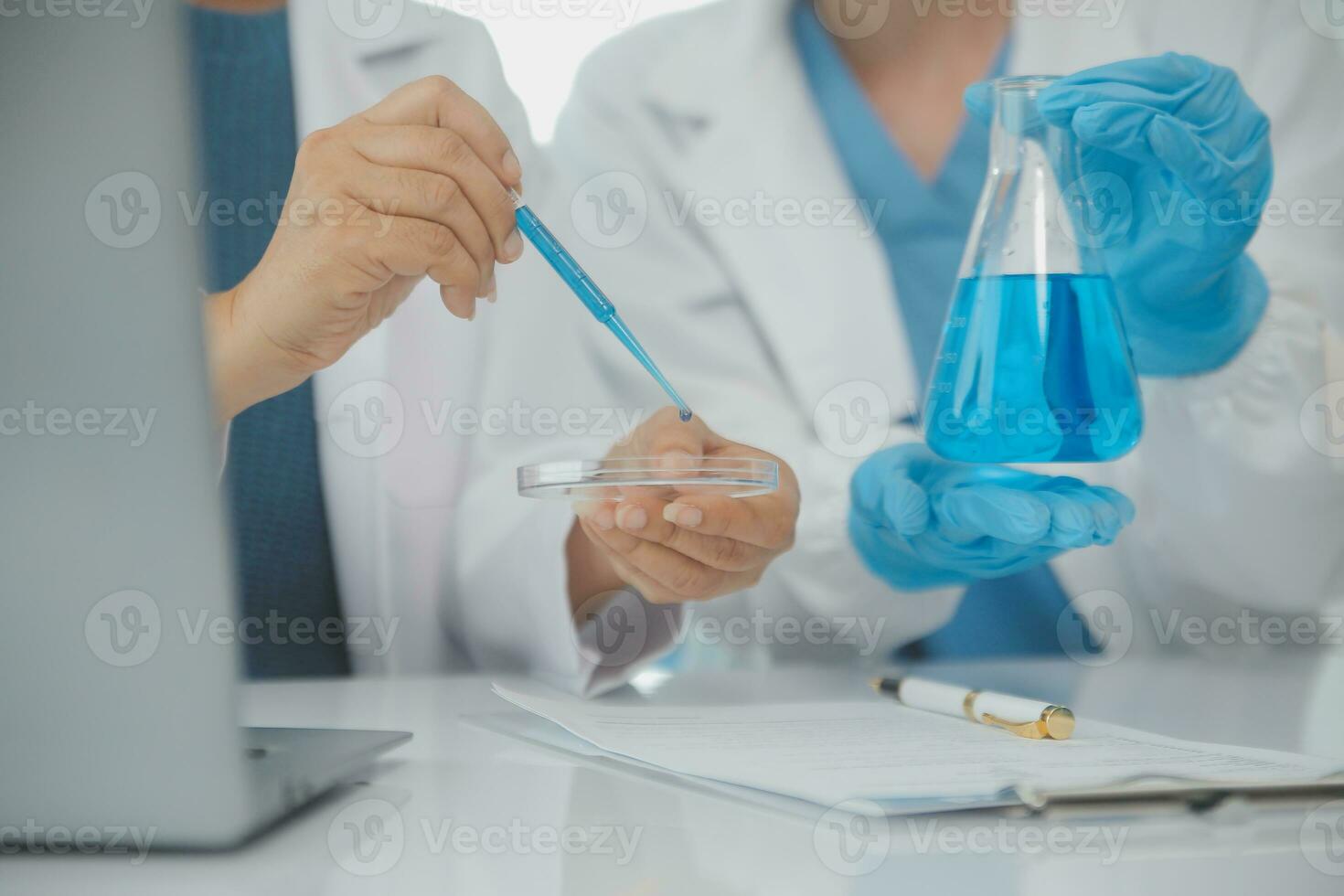Health care researchers working in life science laboratory. Young female research scientist and senior male supervisor preparing and analyzing microscope slides in research lab. photo