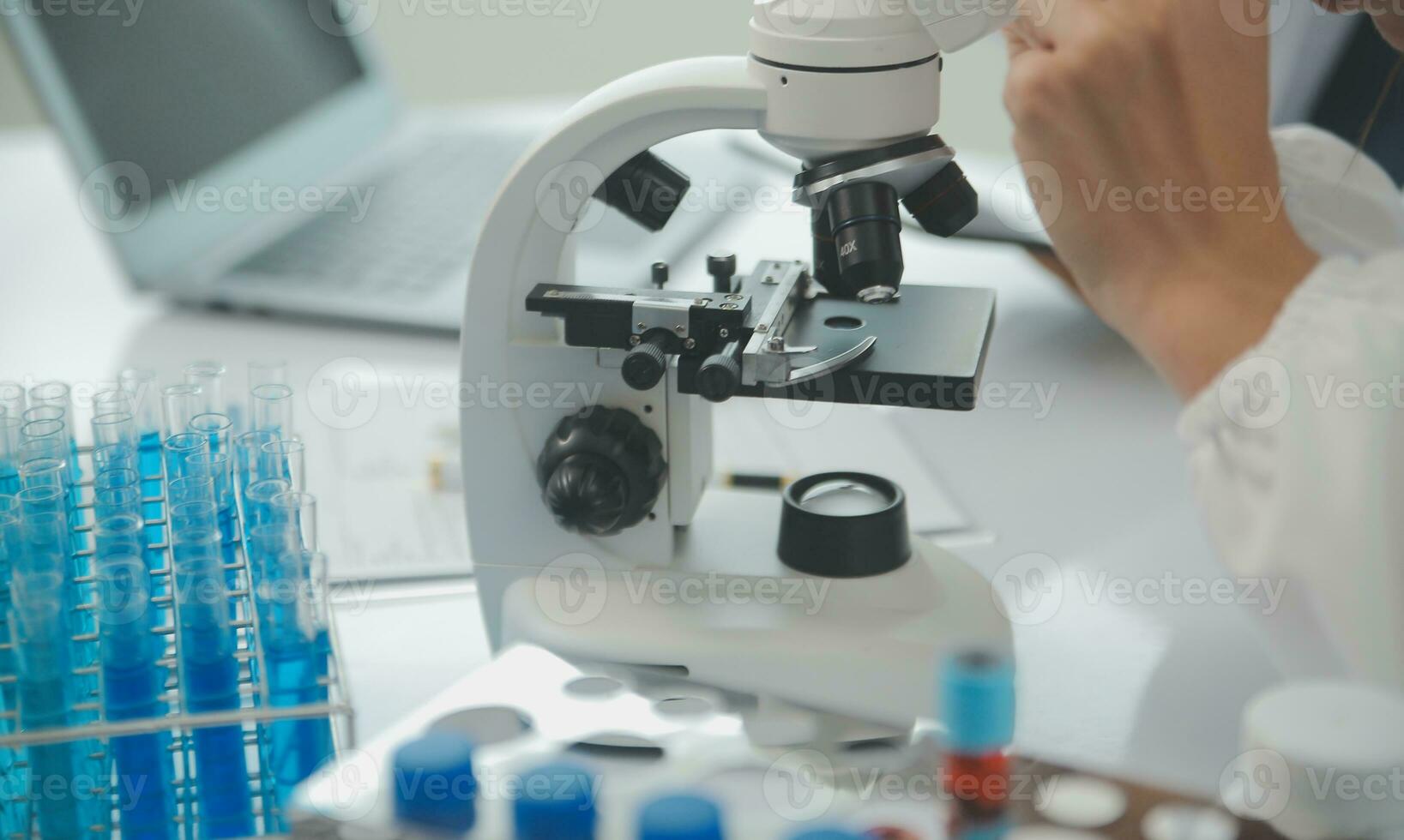 Health care researchers working in life science laboratory. Young female research scientist and senior male supervisor preparing and analyzing microscope slides in research lab. photo