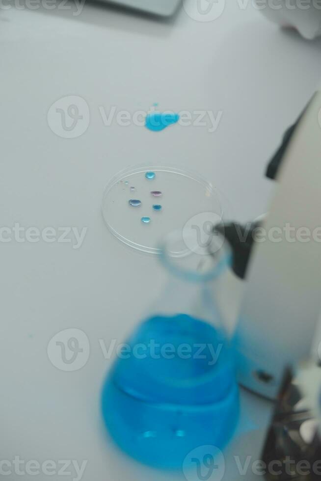 Health care researchers working in life science laboratory. Young female research scientist and senior male supervisor preparing and analyzing microscope slides in research lab. photo