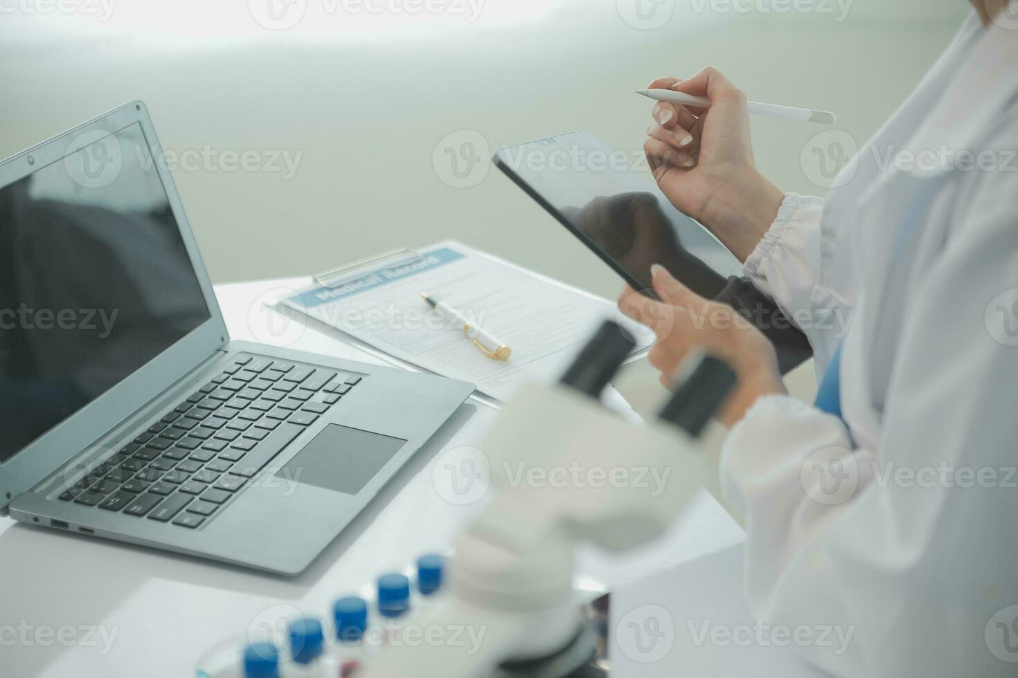 Health care researchers working in life science laboratory. Young female research scientist and senior male supervisor preparing and analyzing microscope slides in research lab. photo