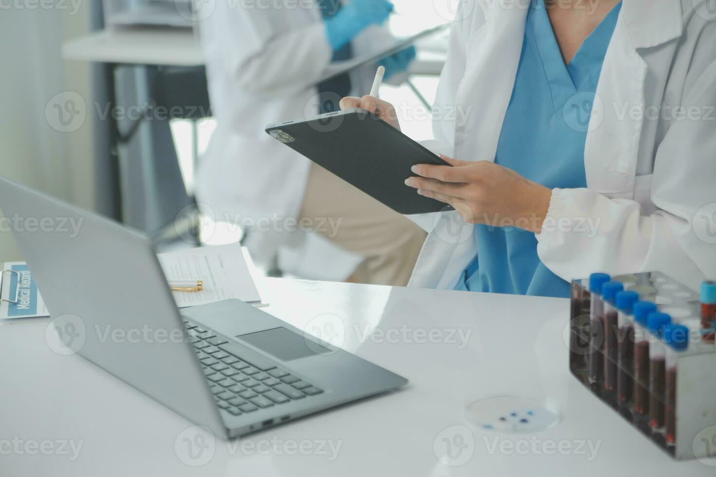 Health care researchers working in life science laboratory. Young female research scientist and senior male supervisor preparing and analyzing microscope slides in research lab. photo