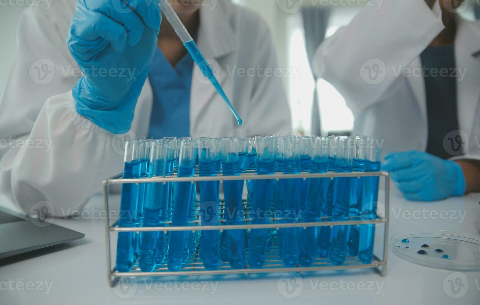 Health care researchers working in life science laboratory. Young female research scientist and senior male supervisor preparing and analyzing microscope slides in research lab. photo