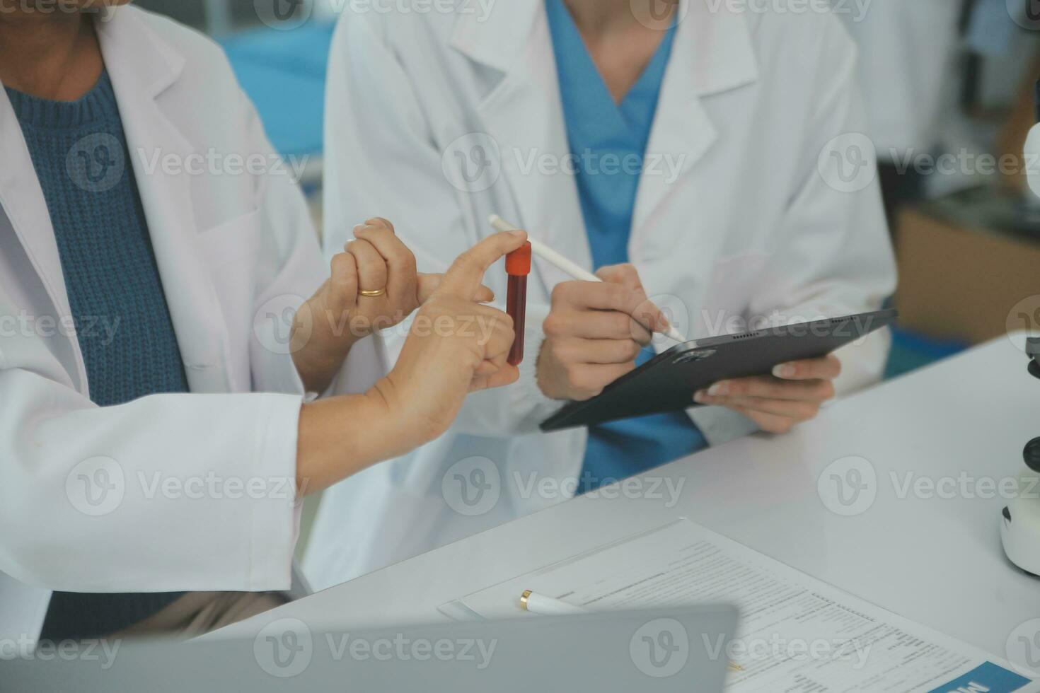 Health care researchers working in life science laboratory. Young female research scientist and senior male supervisor preparing and analyzing microscope slides in research lab. photo