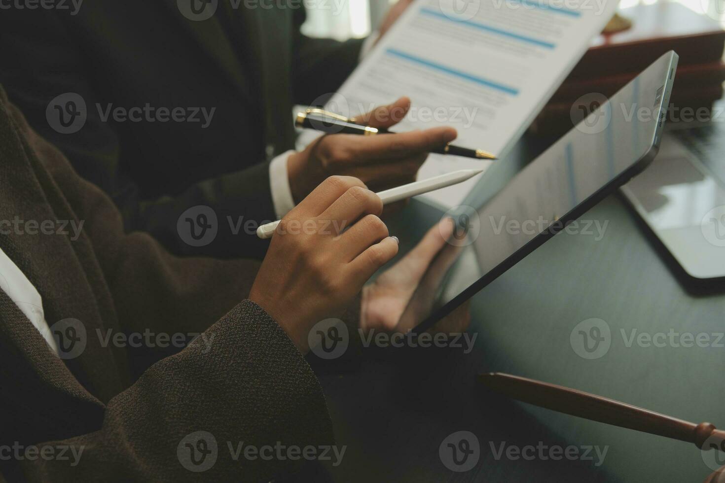 Business and lawyers discussing contract papers with brass scale on desk in office. Law, legal services, advice, justice and law concept picture with film grain effect photo