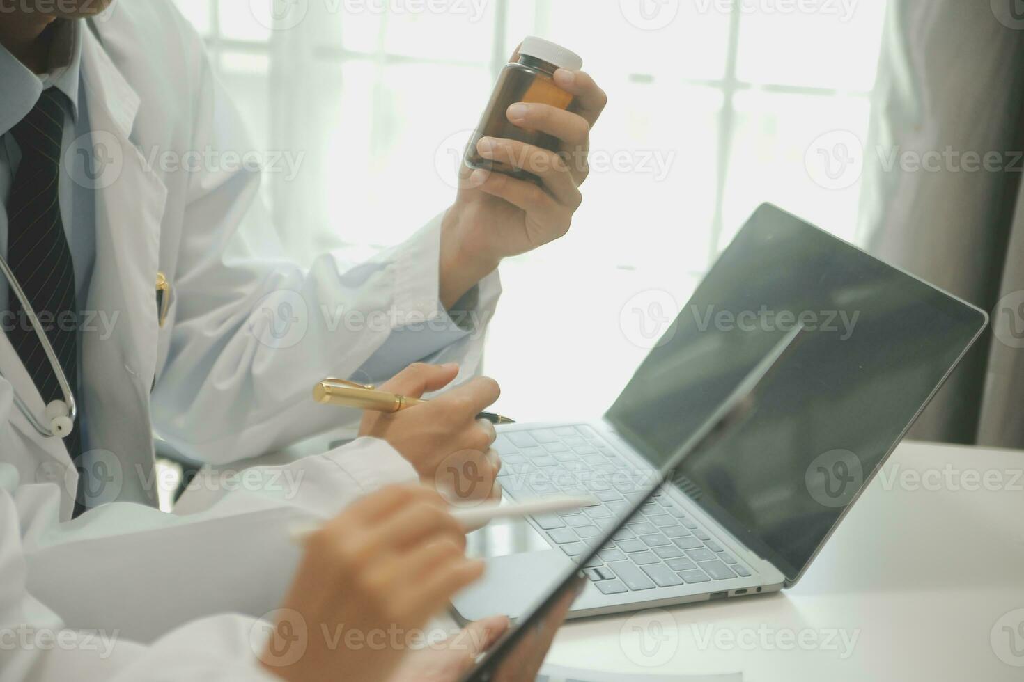 medical team having a meeting with doctors in white lab coats and surgical scrubs seated at a table discussing a patients records,success medical health care, Medicine doctor's working concept photo