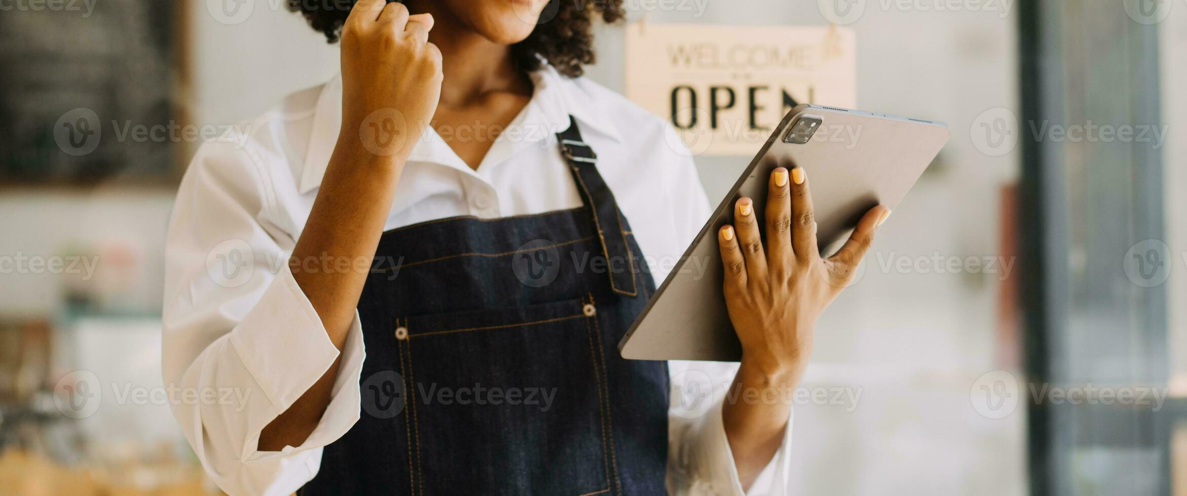 Startup successful small business owner sme beauty girl stand with tablet smartphone in coffee shop restaurant. Portrait of asian tan woman barista cafe owner. SME entrepreneur seller business concept photo