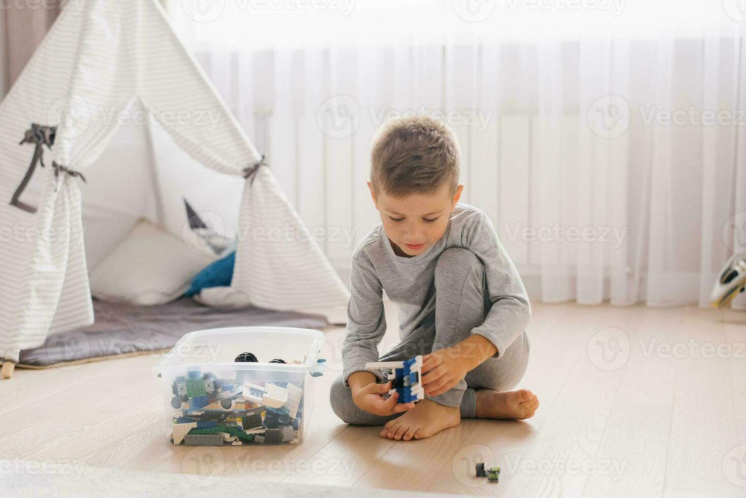 Boy child plays with toys, collects a constructor in a cozy children's room photo