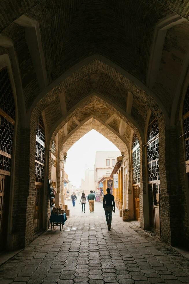 Bukhara, Uzbekistan. December 2022. Shopping malls and tourists in the arch photo