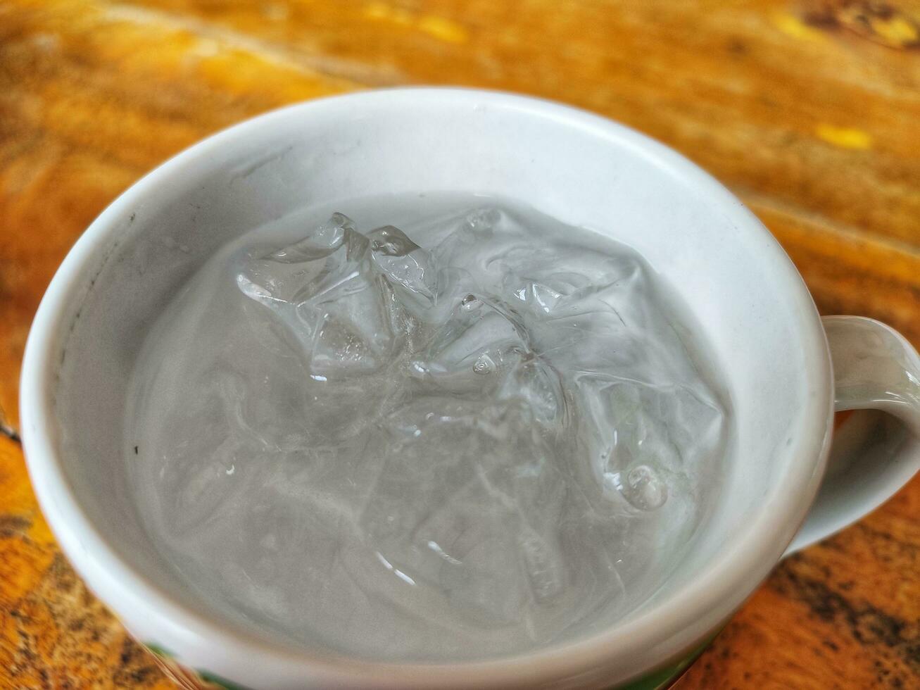 ice and water in the cup above table photo