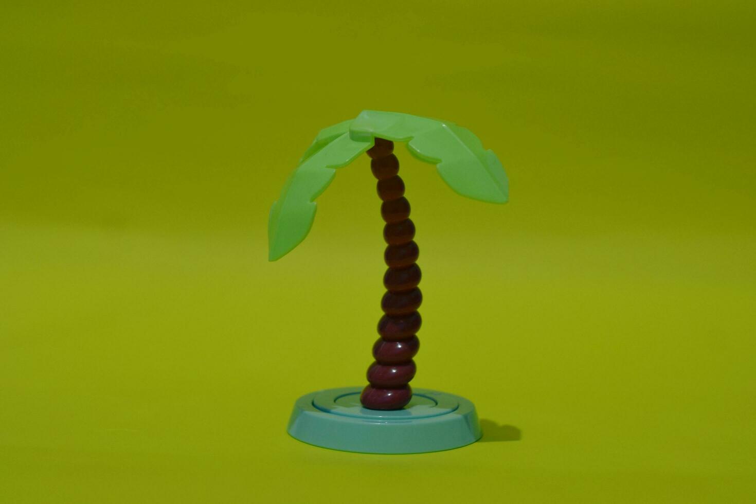Artificial coconut tree made of plastic isolated on yellow background photo