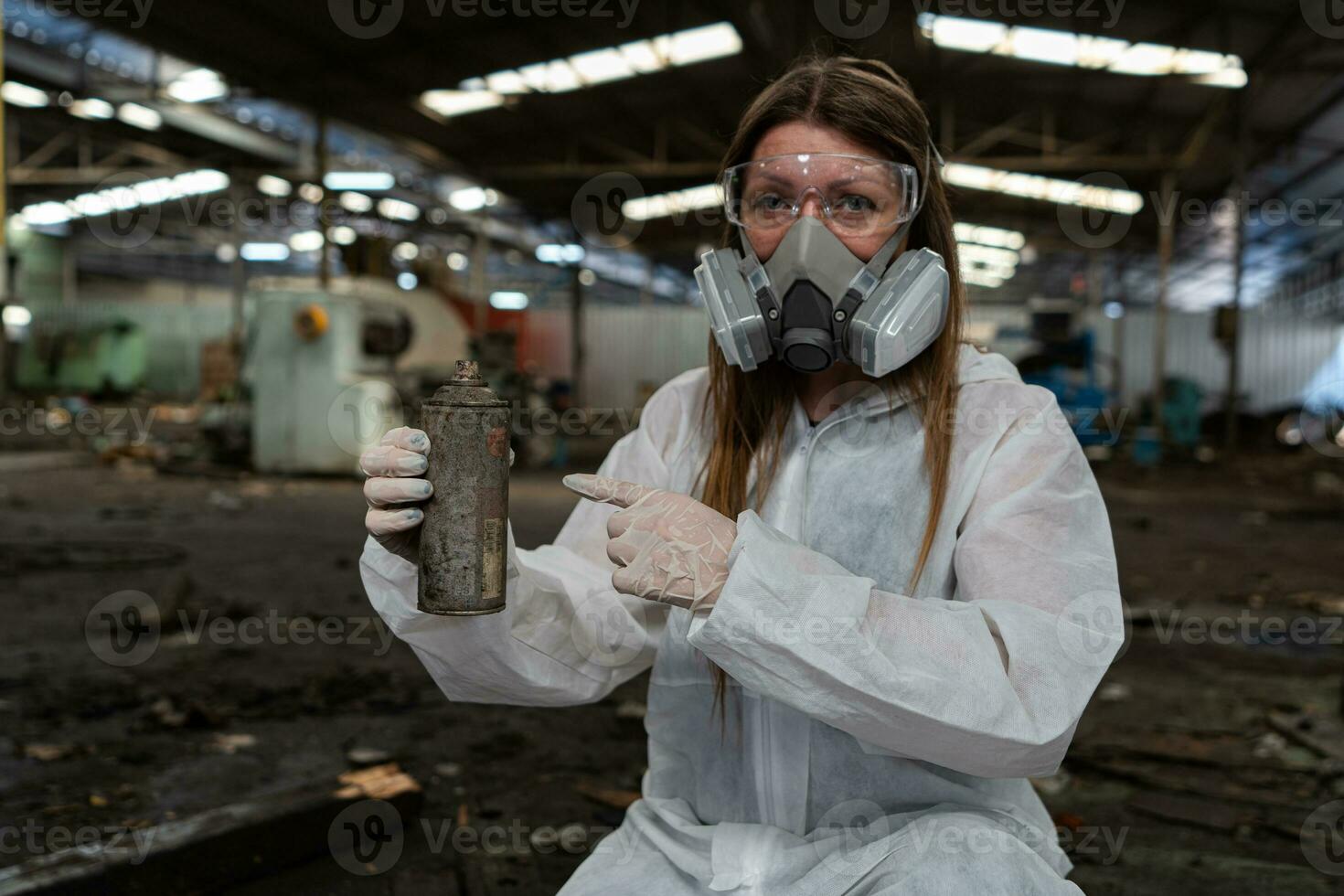 emergencia contaminación fábrica concepto. hembra químico vistiendo ppe y gas máscara inspeccionando petróleo en fábrica piso foto