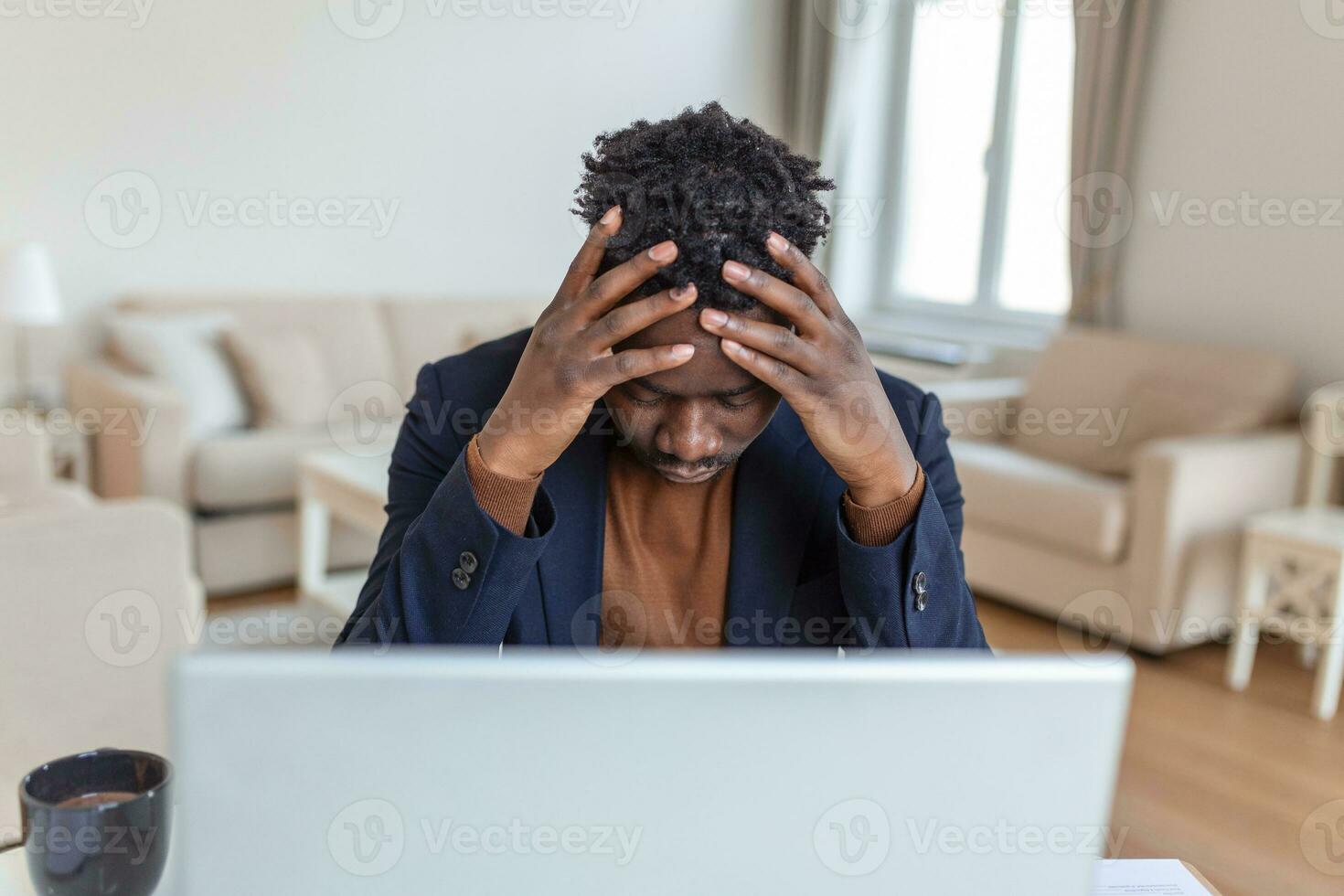Stressed tired African American man touching temples, suffering from headache after long hours work, overworked overwhelmed businessman sitting at desk, feeling unwell photo