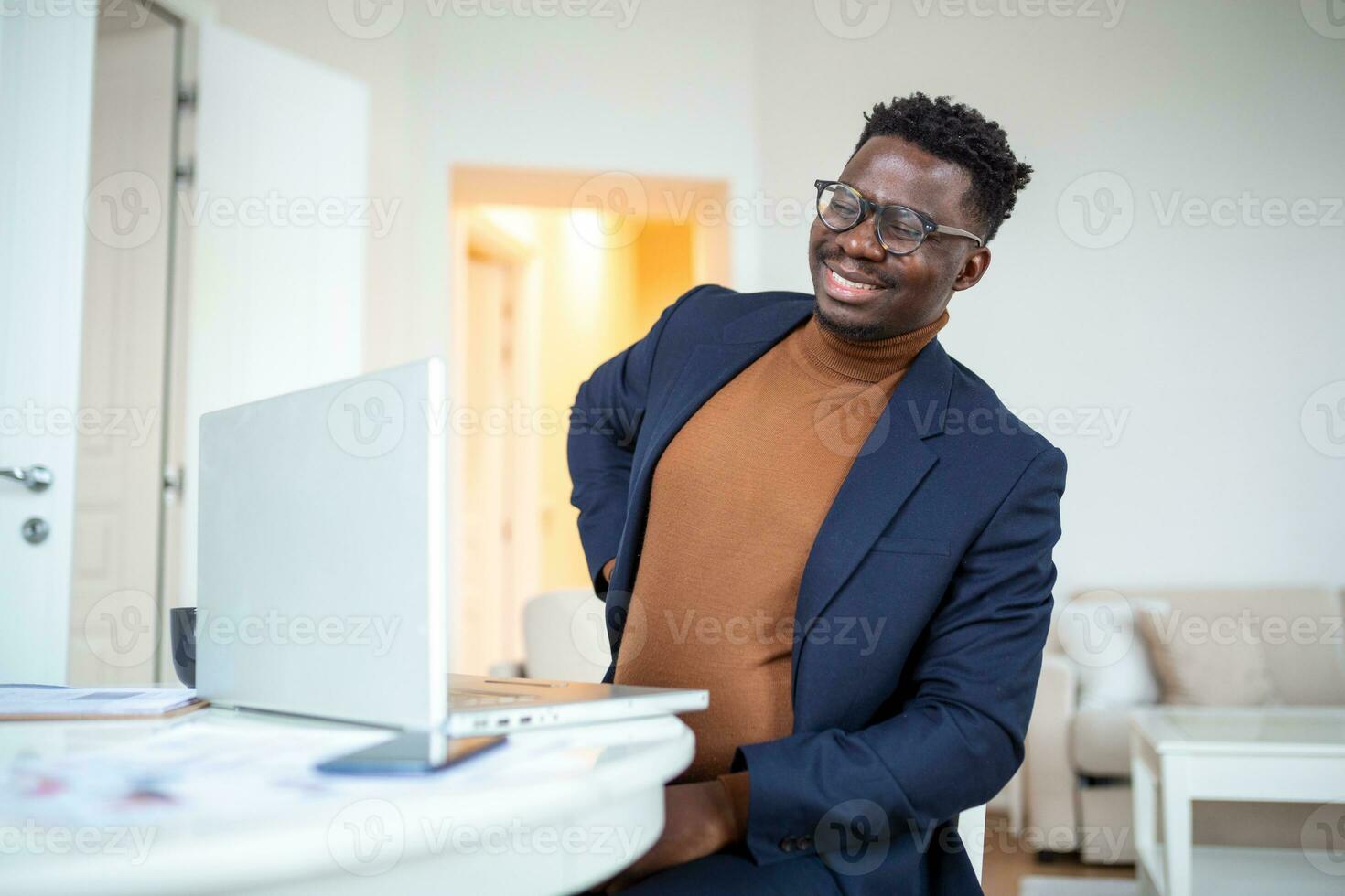 Businessman working sitting at desk feels unhealthy suffers from lower back pain. Damage of intervertebral discs, spinal joints, compression of nerve roots caused by wrong posture and sedentary work. photo