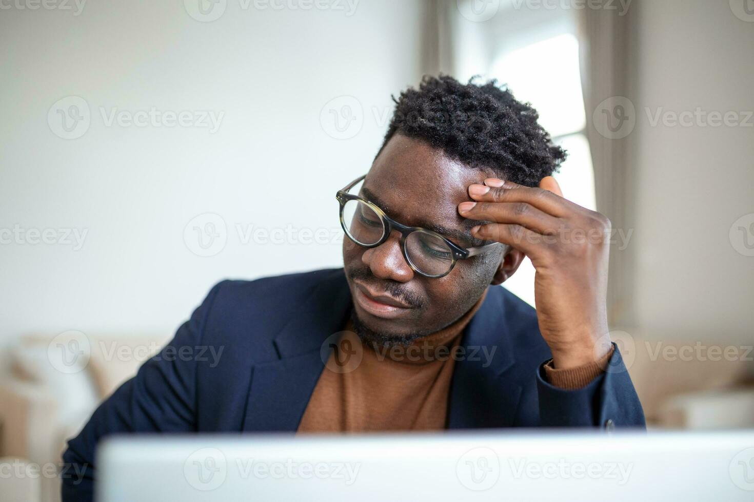 Stressed tired African American man touching temples, suffering from headache after long hours work, overworked overwhelmed businessman sitting at desk, feeling unwell photo