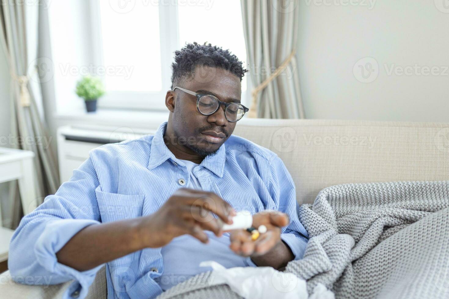 sick wasted man lying in bed suffering cold and winter flu virus having medicine tablets in health care concept Drinking pills with glass of water photo