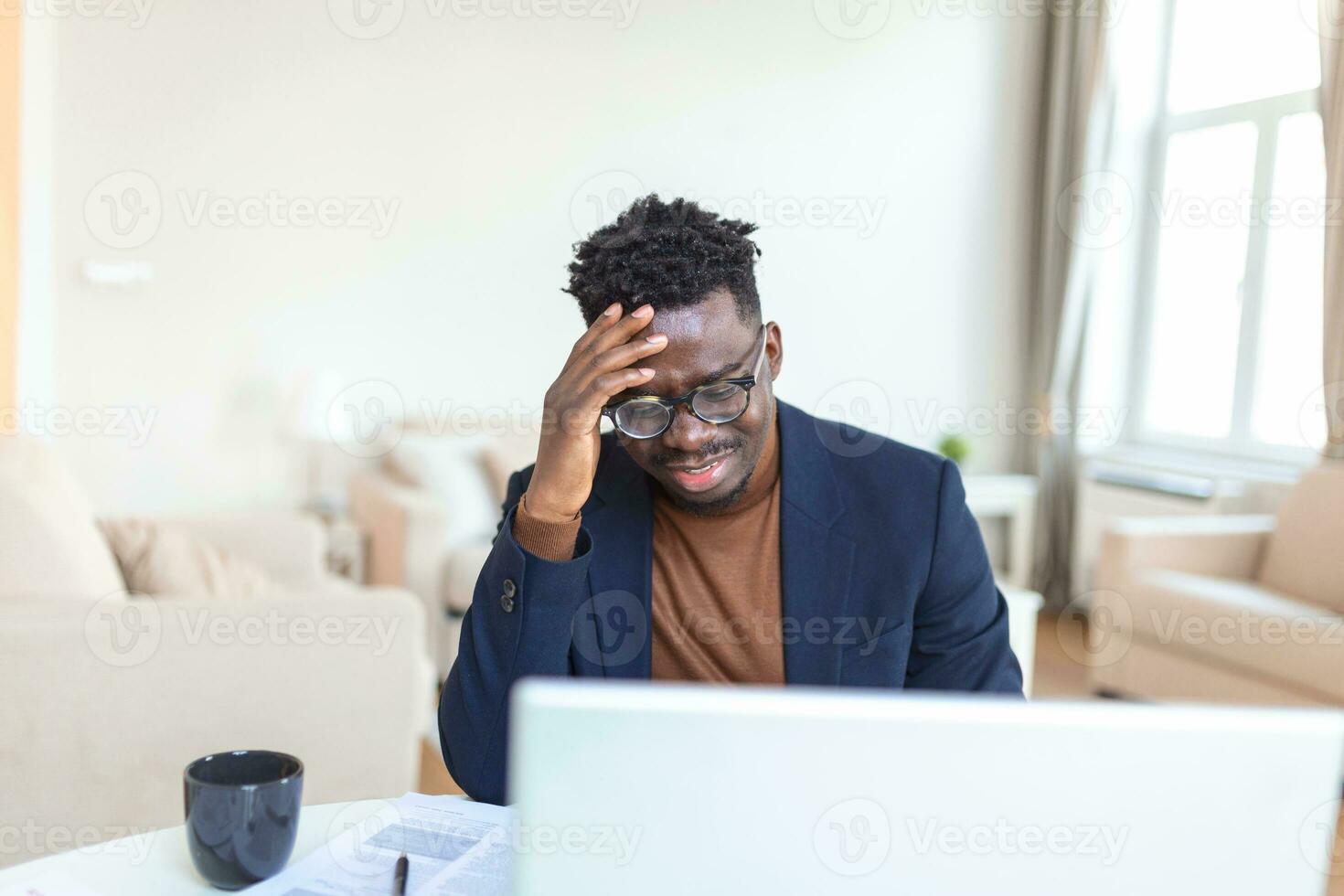 Stressed tired African American man touching temples, suffering from headache after long hours work, overworked overwhelmed businessman sitting at desk, feeling unwell photo
