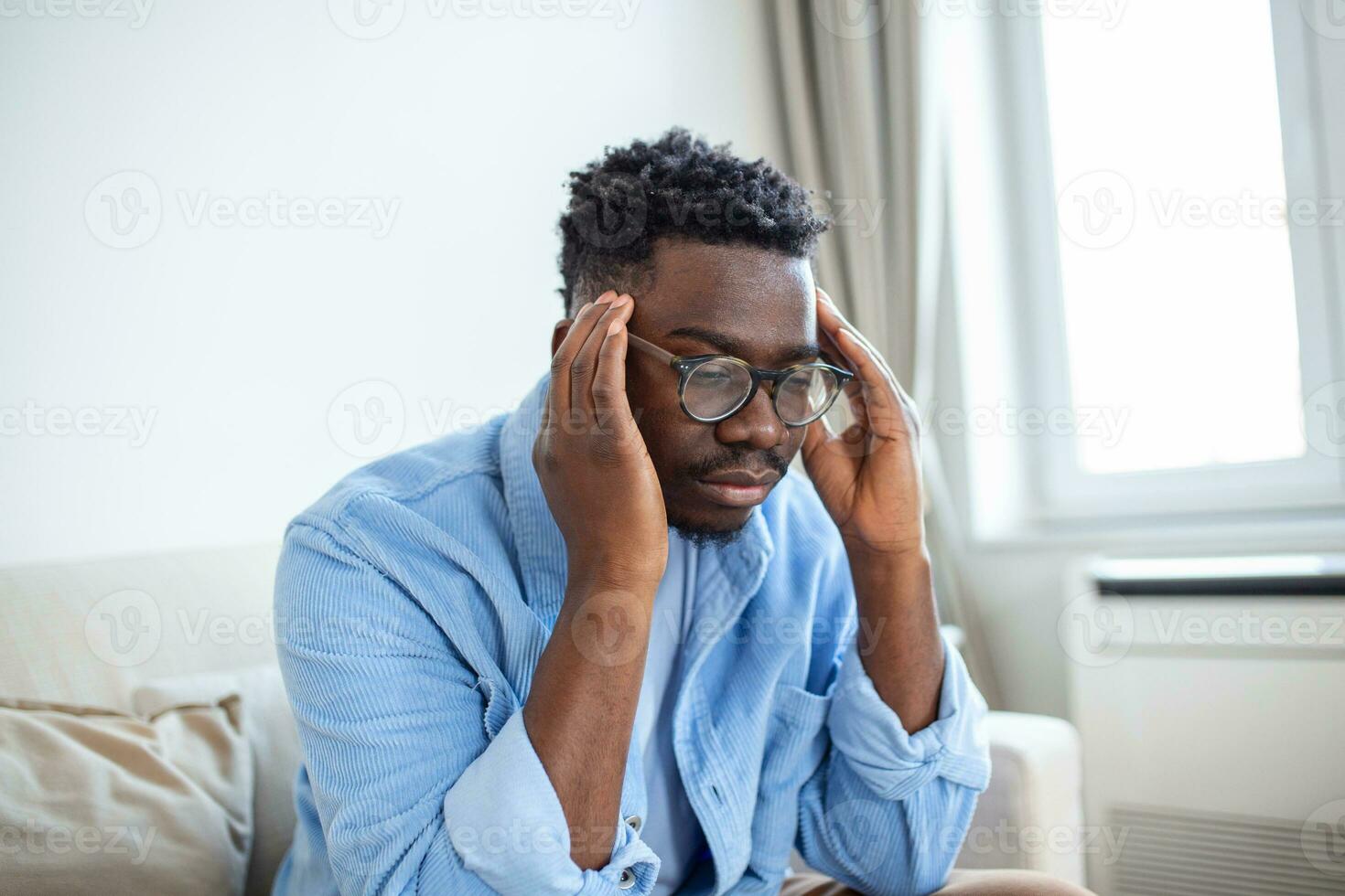 Tired African American man taking off glasses, exhausted massaging nose bridge, suffering from eye strain after long computer work, feeling pain, health problem concept photo