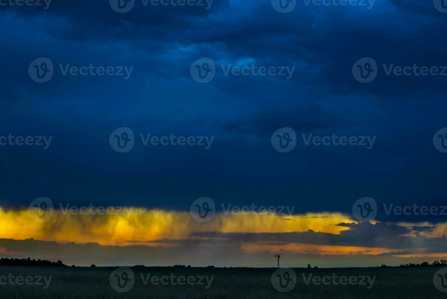 a large field with a sky filled with clouds photo