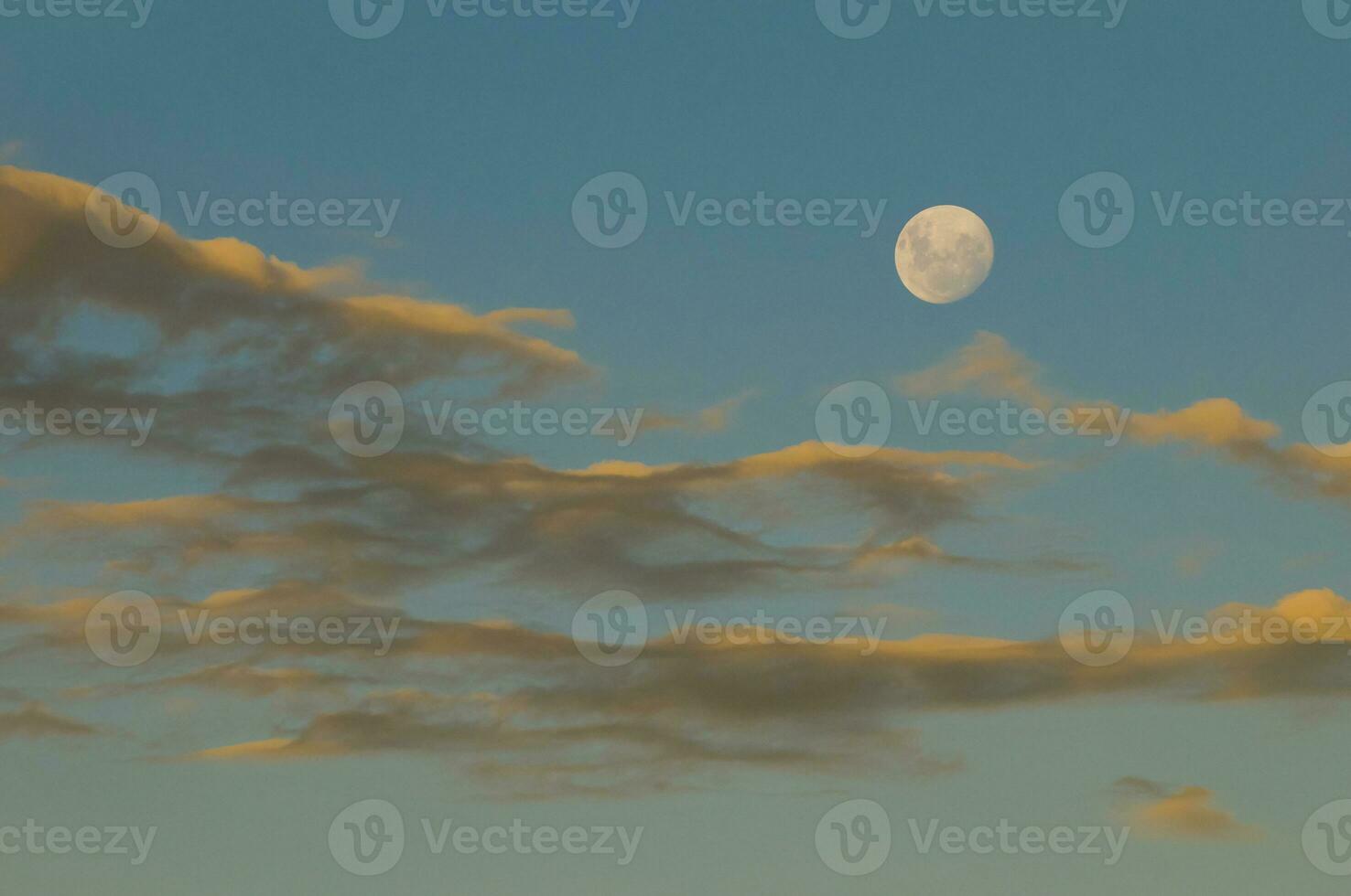 un lleno Luna es visto en el cielo encima nubes foto