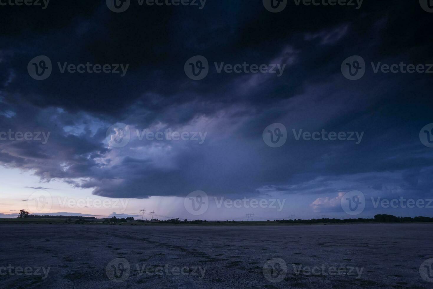 un Tormentoso cielo terminado un arenoso playa a oscuridad foto