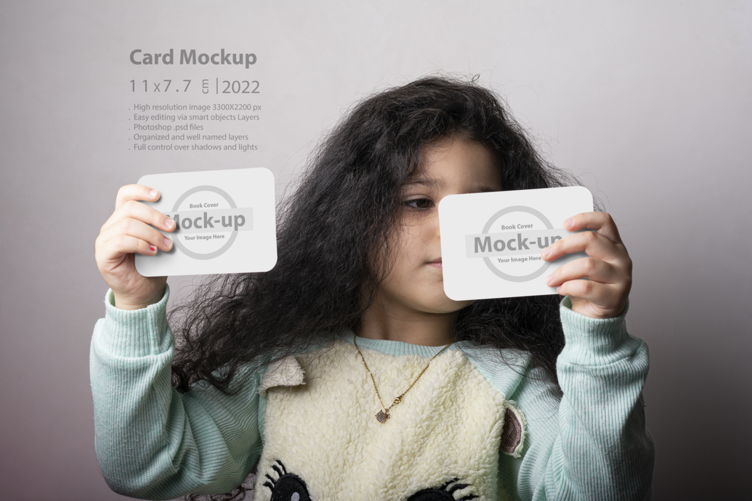 Little girl portrait holding two flash cards in hands psd