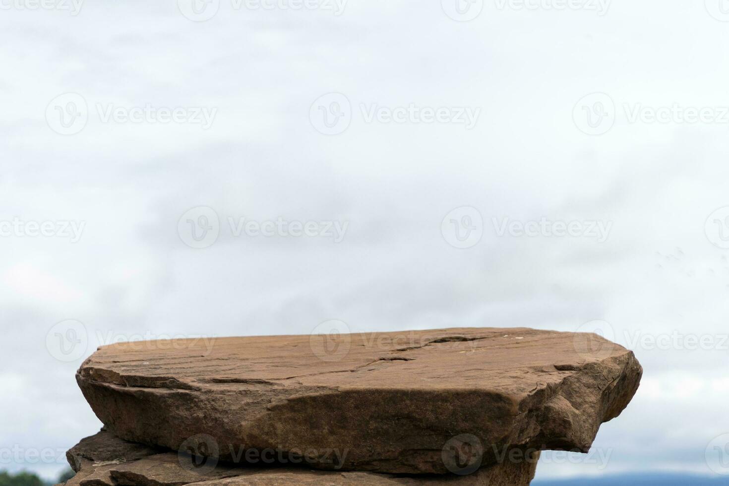 Against the background of the blue sky, a podium made of natural stone in summer nature photo