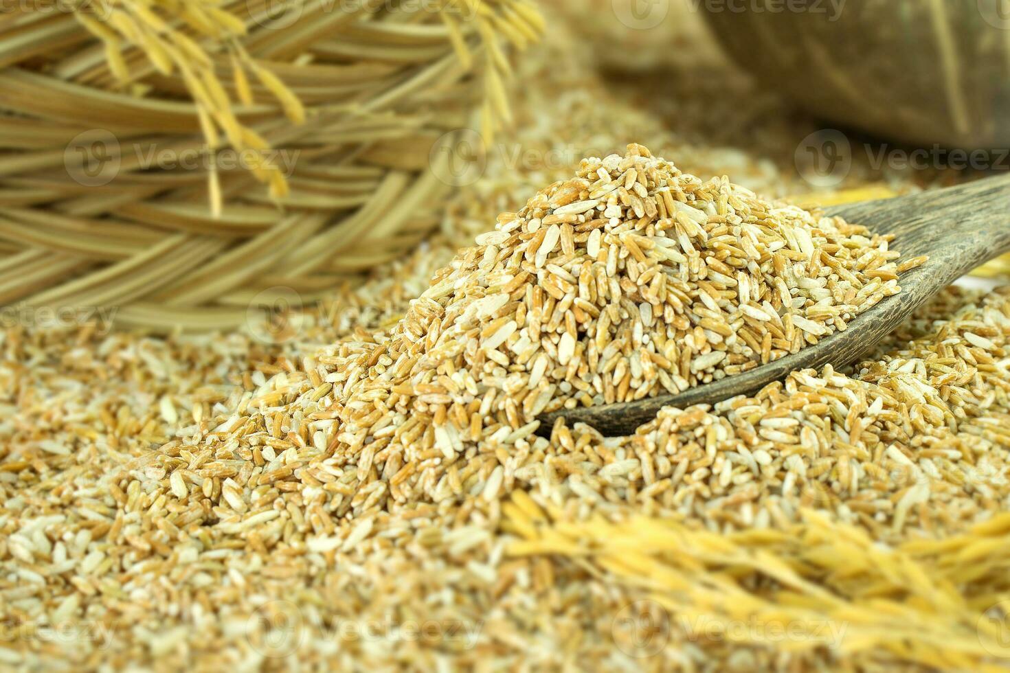 Organic rice grain in wooden spoon on wooden table photo