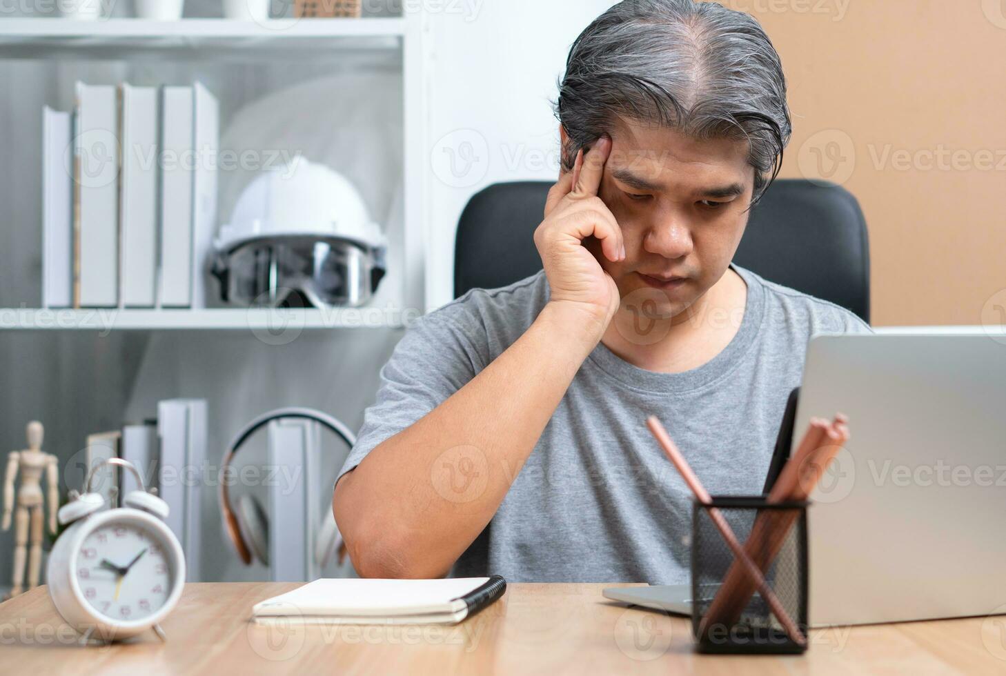 Asian Businessman are working at home at night To solve business problems After being affected by the lockdown. Concept of business planning, vision, and mission to cope with the economic crisis photo