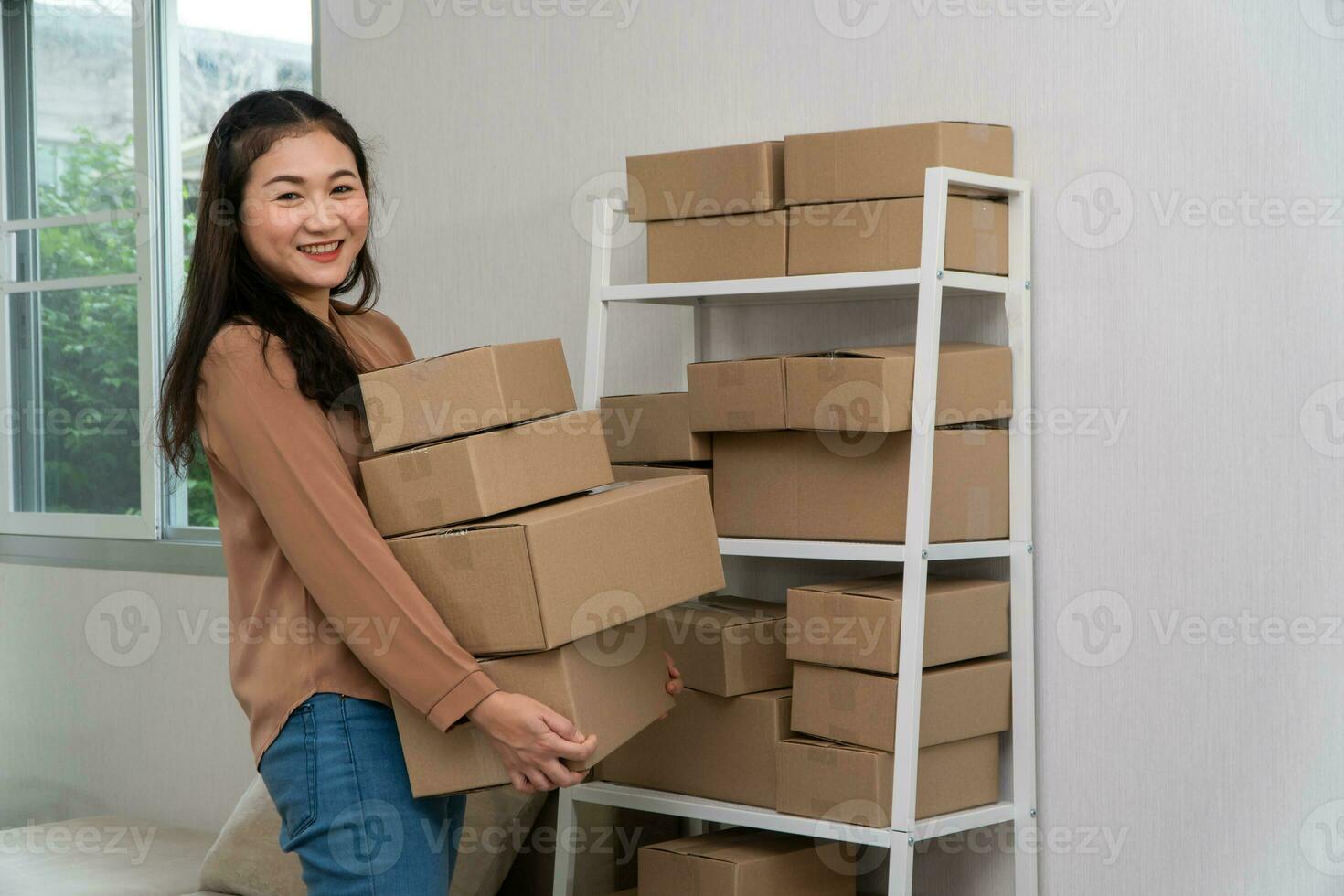 Happy young asian entrepreneurs are arranging boxes for delivering products to customers. Small business owner and success in online business concepts. photo