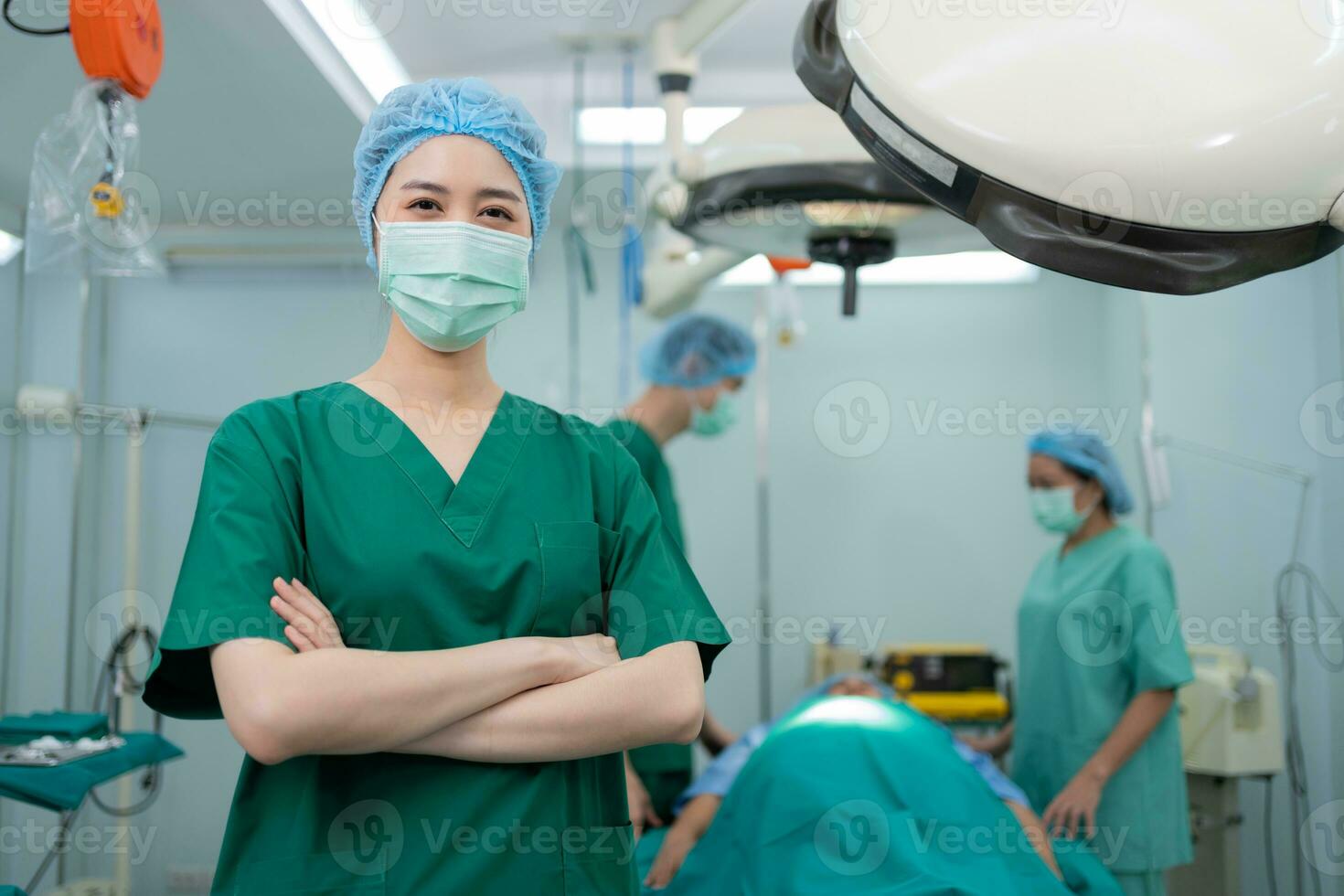 Portrait of Asian surgeon and nurse with medical mask standing with arms crossed in operation theater at a hospital. Team of Professional surgeons. Healthcare, emergency medical service concept photo