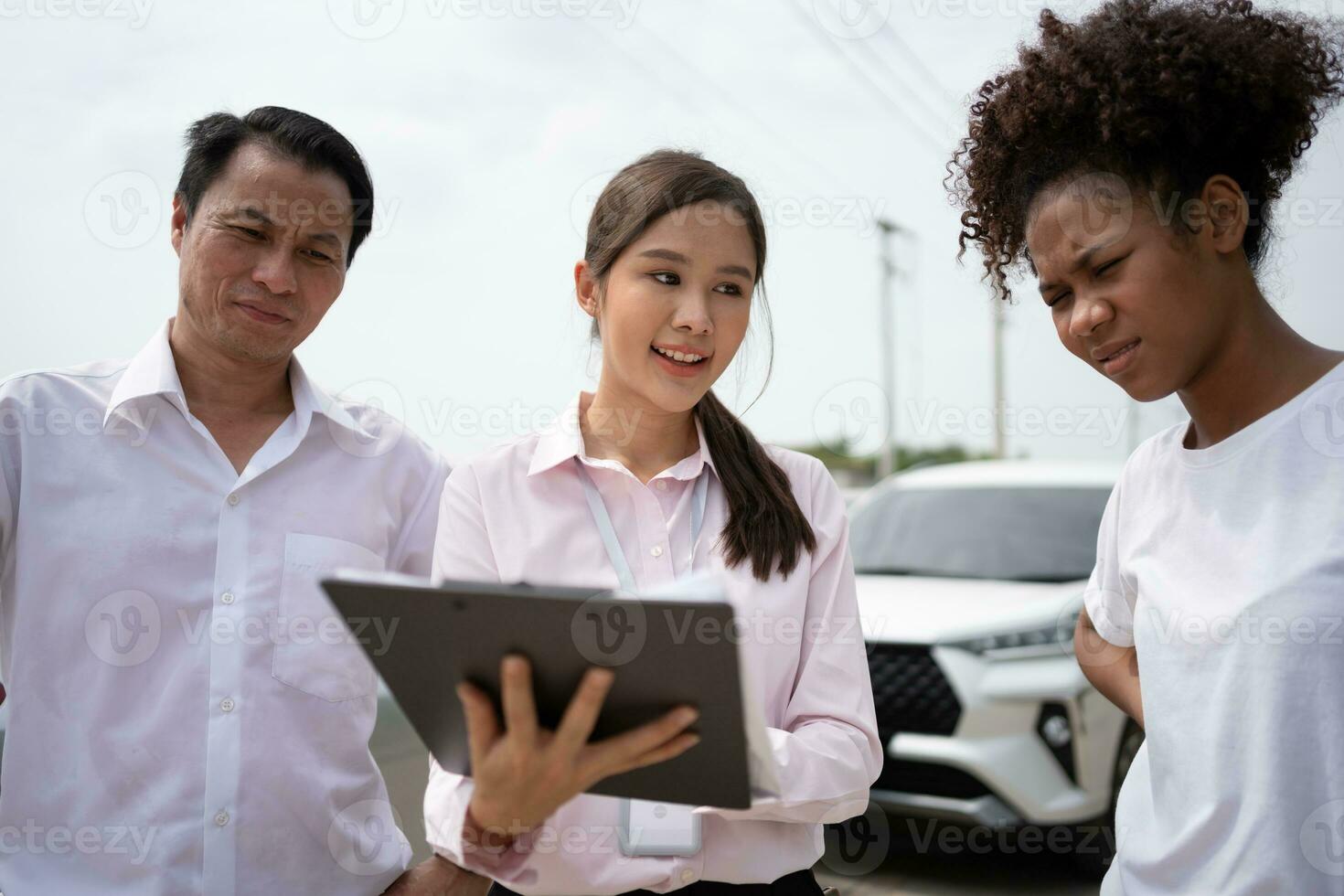 Two Asian driver Talk to Insurance Agent for examining damaged car and customer checking on report claim form after an accident. Concept of insurance and car traffic accidents. photo