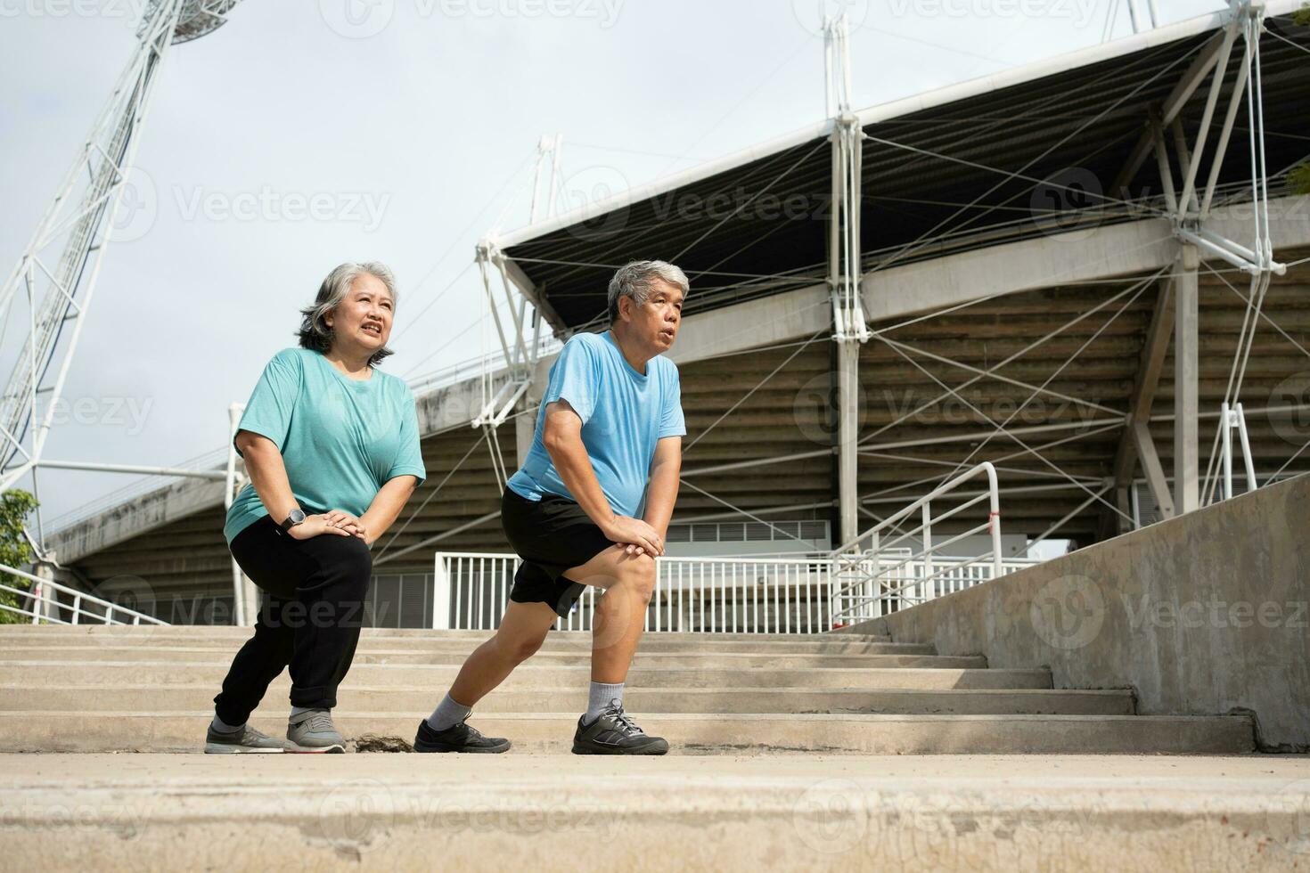 Asian senior couples wear sports outfit and warming up muscles  before exercise at outdoor in the morning. Happy elderly outdoor lifestyle concept, Full length of active happy elderly family couple photo