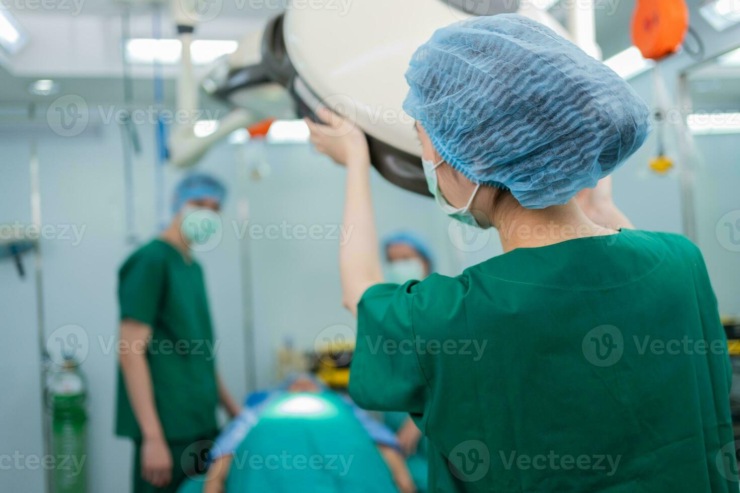 Behind of Asian surgeon with a medical mask standing in the operation theater at a hospital. Team of Professional surgeons. Healthcare, emergency medical service concept photo