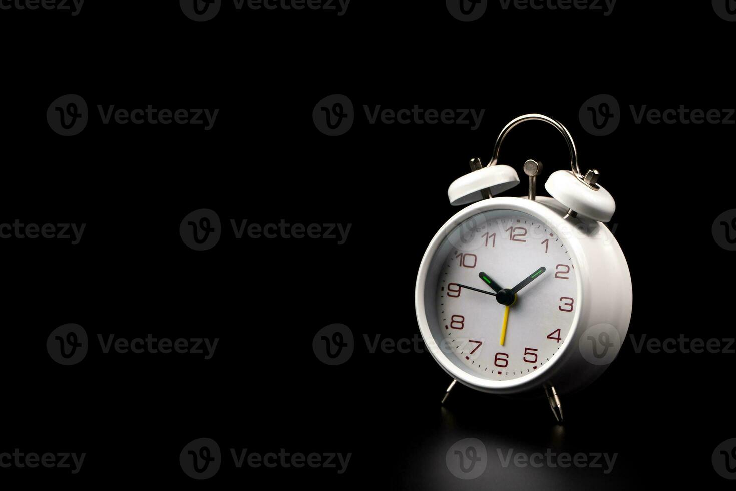 White alarm clock on black background. photo