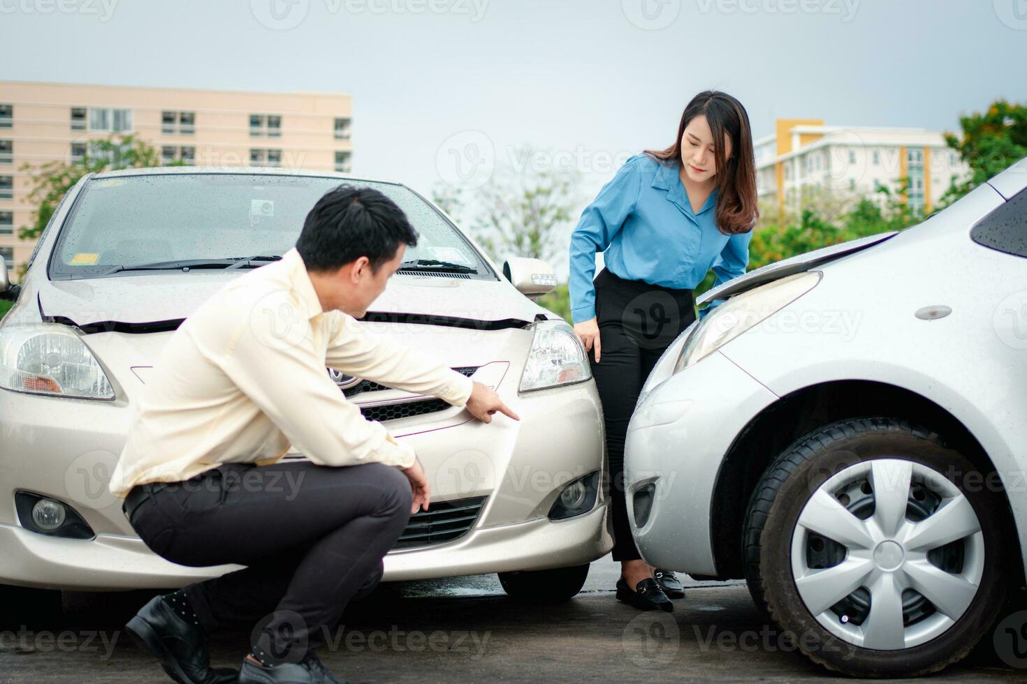 Two drivers check for damage after a car accident before taking pictures and sending insurance. Online car accident insurance claim idea after submitting photos and evidence to an insurance company.