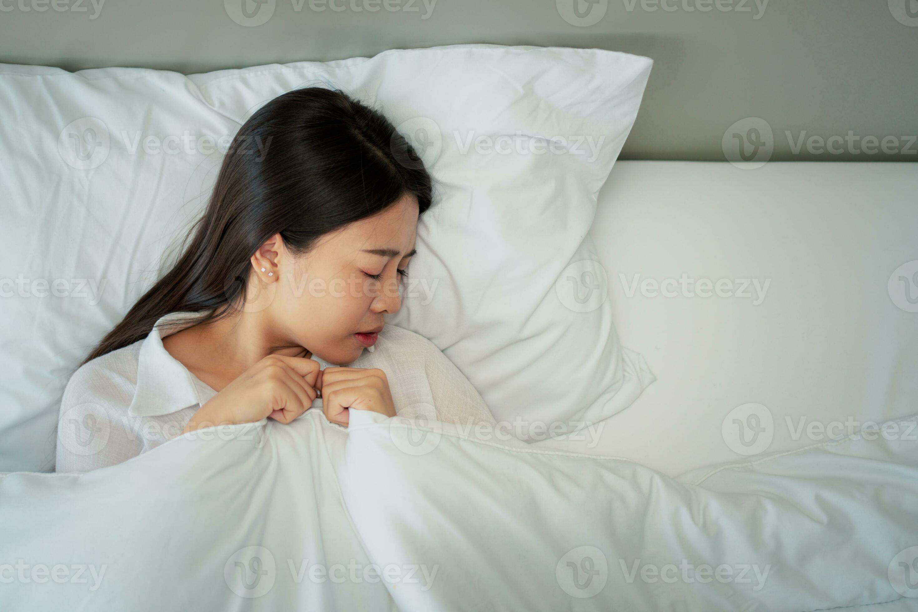 Unhappy exhausted woman closed eyes lying in bed cause of Headache