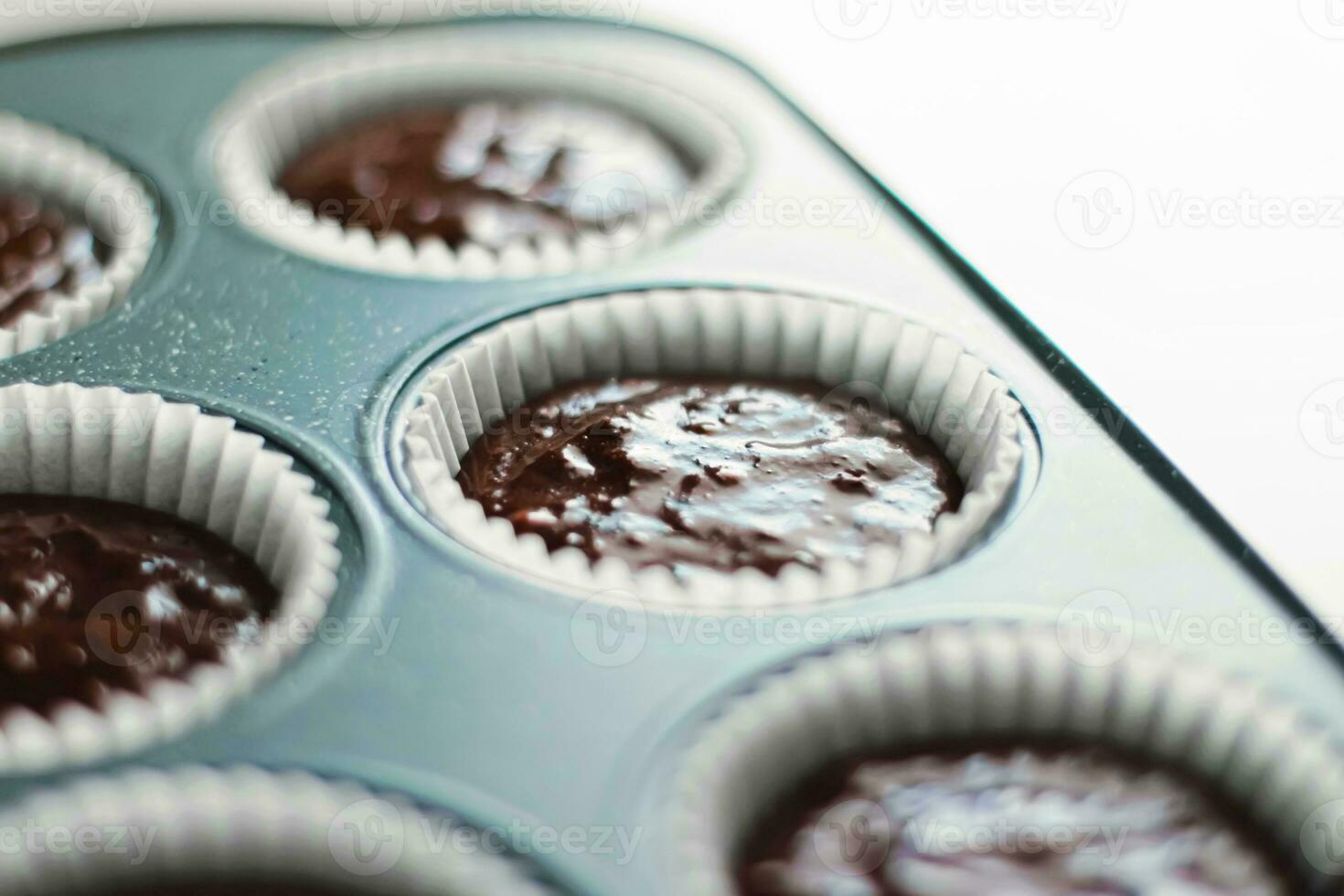 Chocolate muffin or cupcake batter in a pan ready to bake, homemade comfort food recipe photo