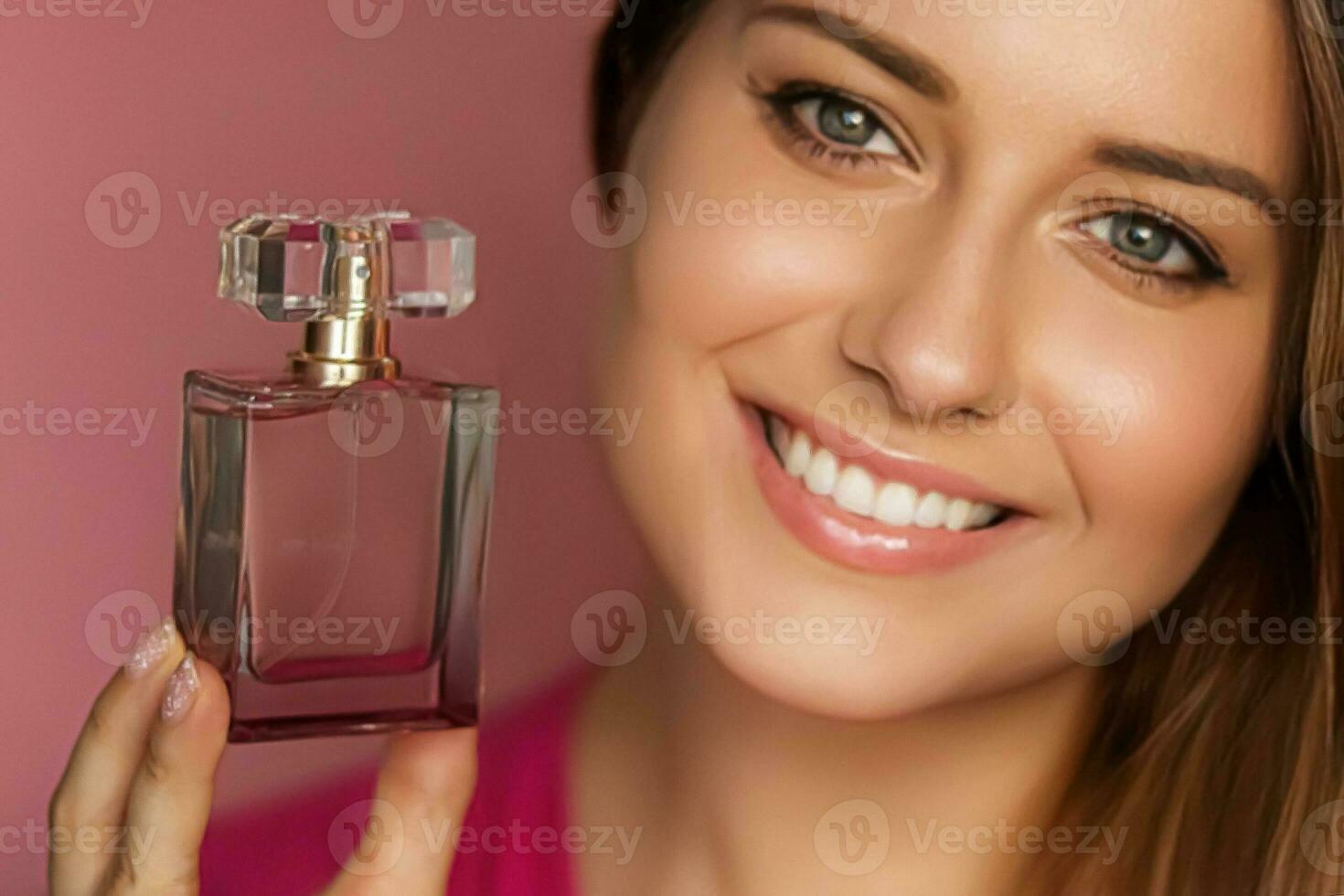 Perfume, beauty product and cosmetics model face portrait on pink background, beautiful woman holding fragrance bottle with floral feminine scent, fashion and makeup photo
