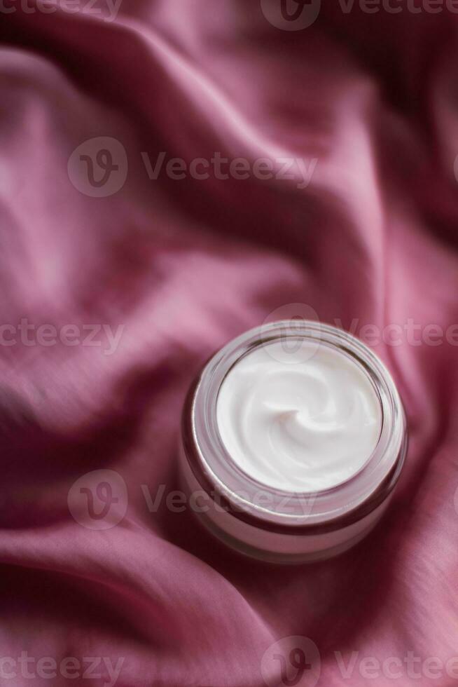 lujo cara crema tarro en un suave rosado seda foto