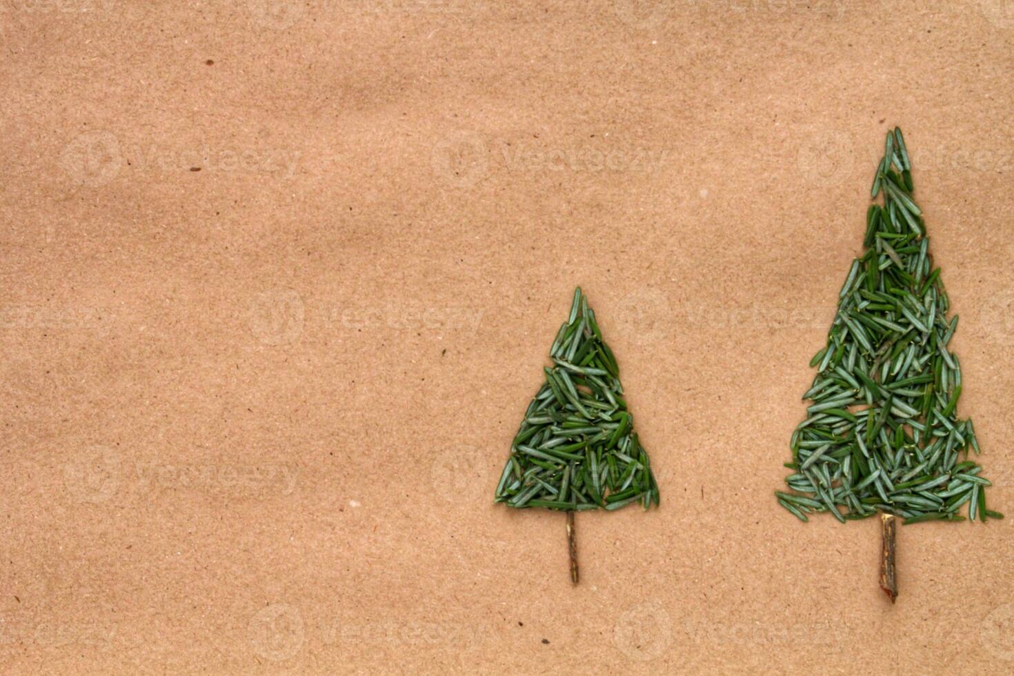 Green srpuce needles Christmas tree pattern on craft recycled paper. Ecological minimal design for holiday postcard. Eco friendly, zero waste, recycle, diy, nature concept. Flatlay, lay out, top view photo