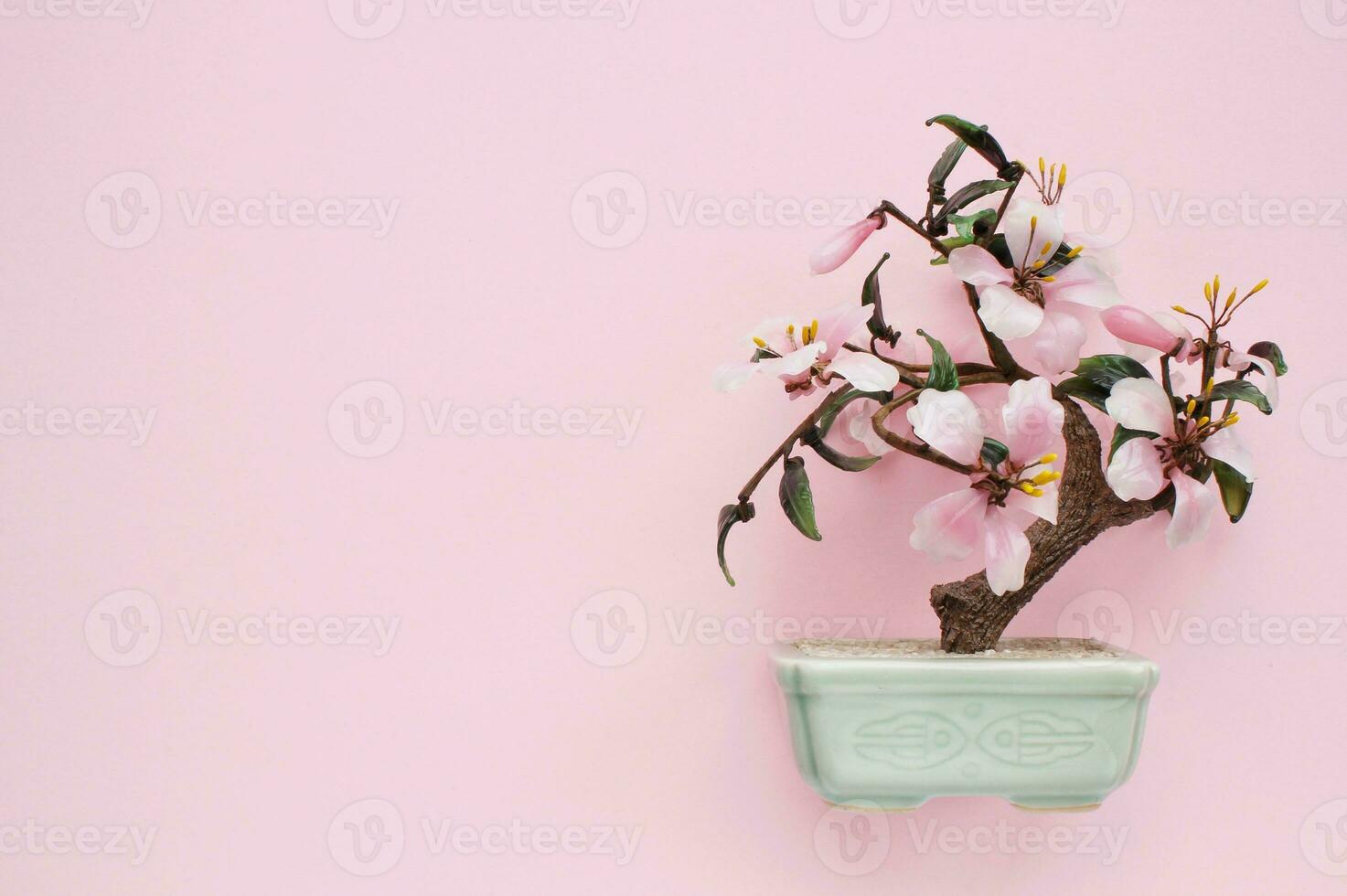 Artificial sakura bonsai tree on ceramic pot with pink background