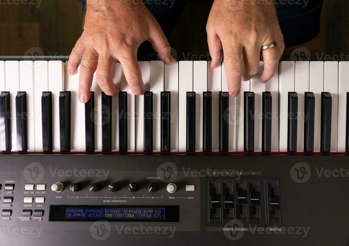 manos masculinas practicando en el teclado del piano electrónico. foto